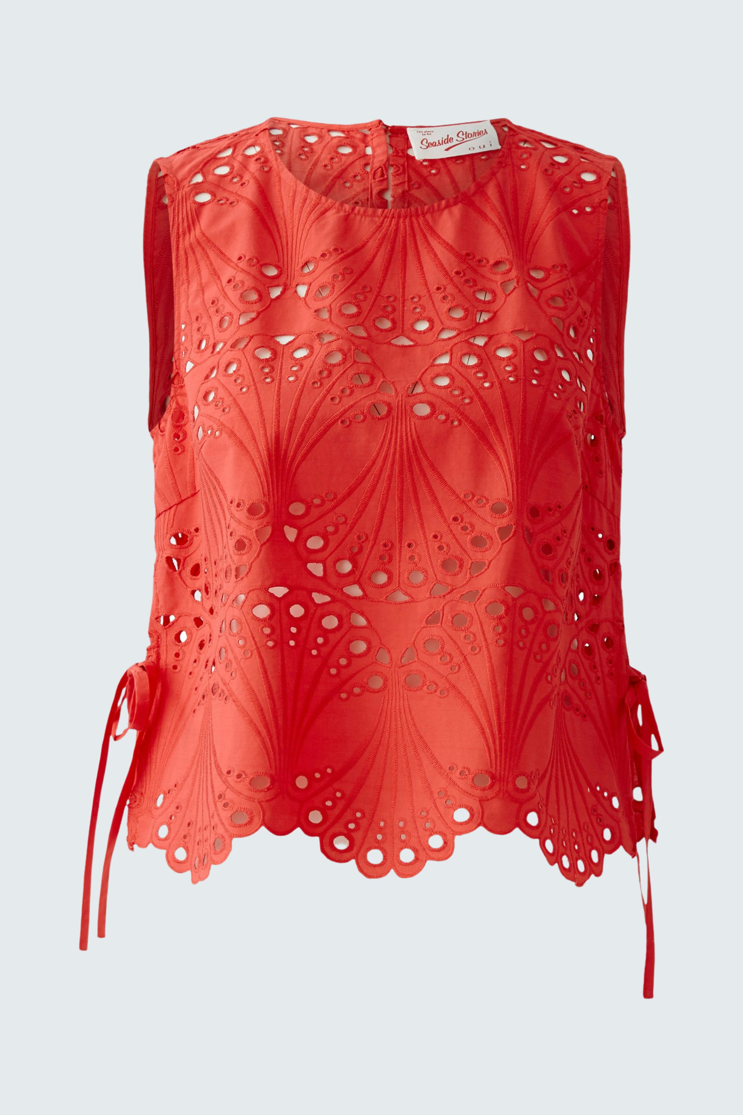 Stylish women's top: Bright red sleeveless top with intricate cut-out design and side ties.