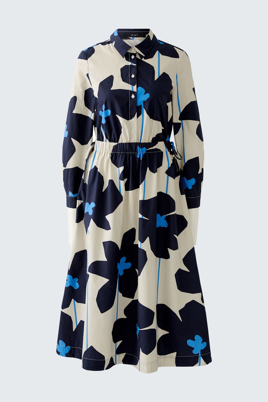Stylish midi dress: A woman in a floral-patterned dress with a cinched waist and button-up collar.