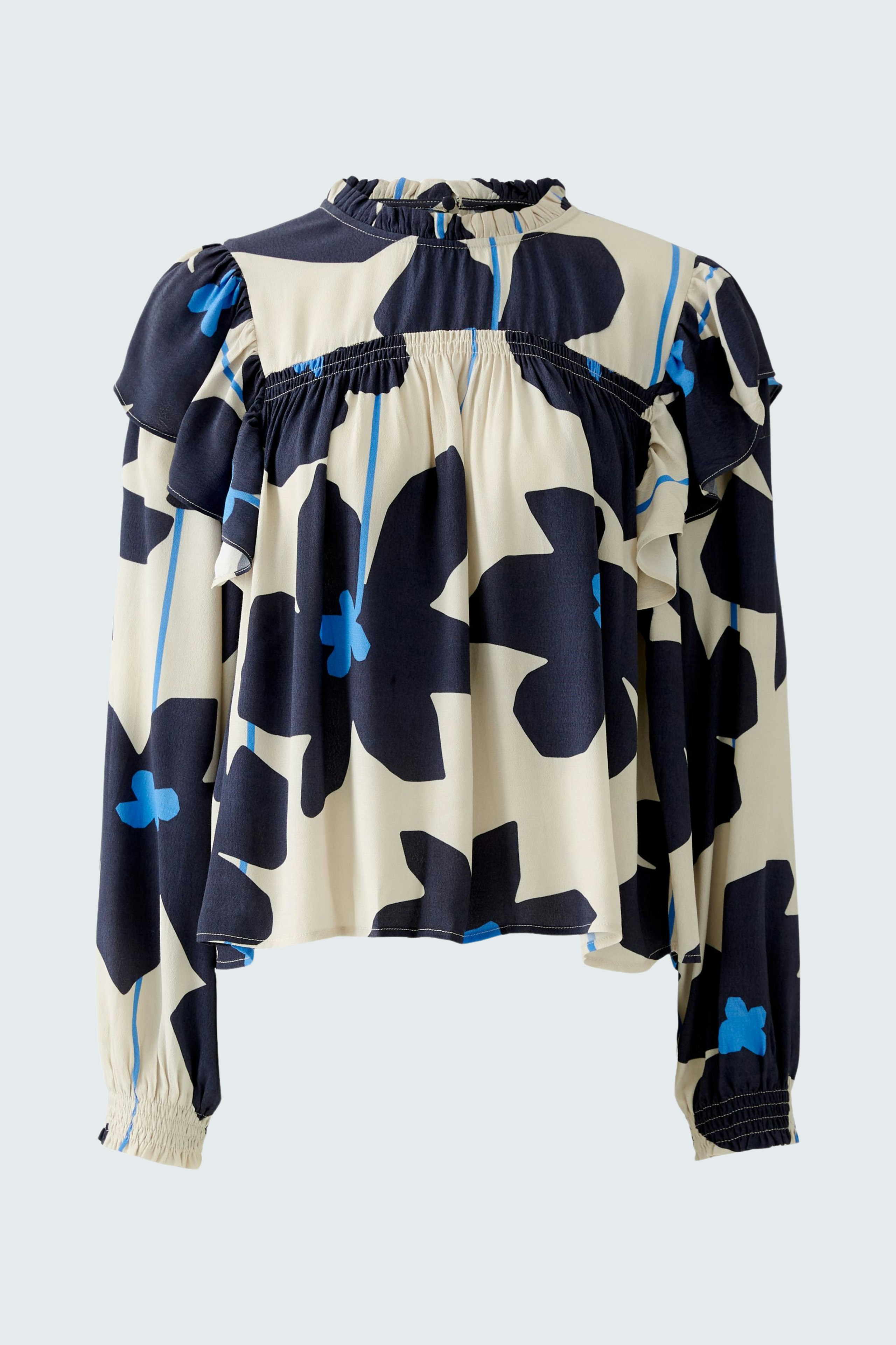 Stylish blouse: A woman in a floral-patterned blouse with ruffles and a relaxed fit.