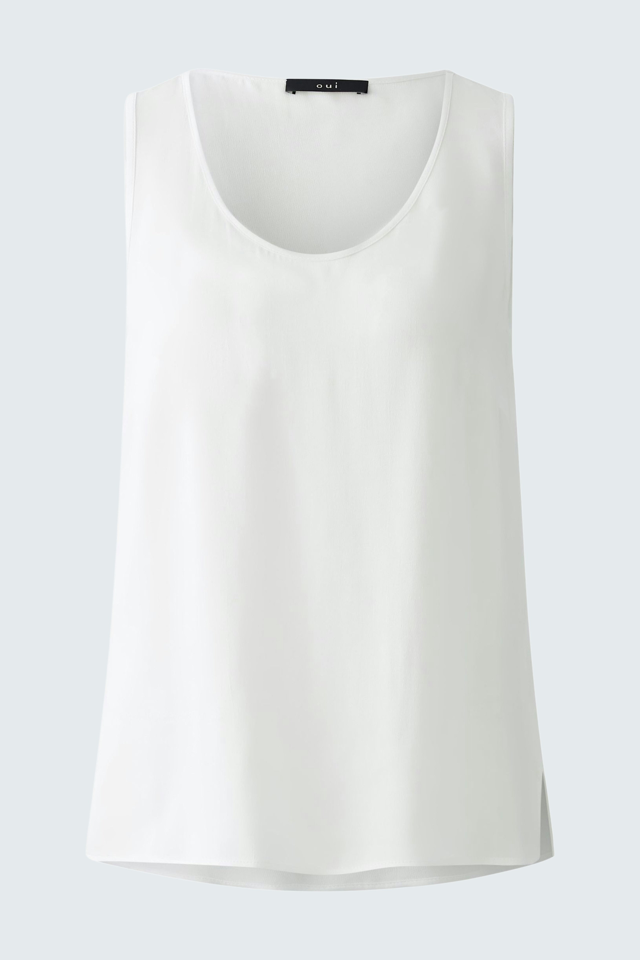 Elegant women's top: A woman in a white sleeveless top, perfect for casual or formal occasions.