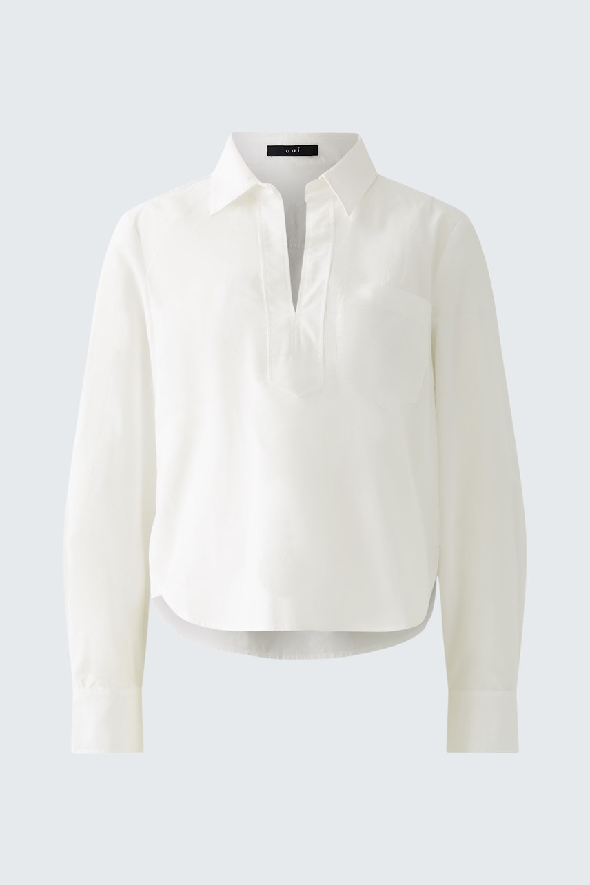 Chic women's blouse: A woman in a white blouse with a relaxed fit and a stylish collar.