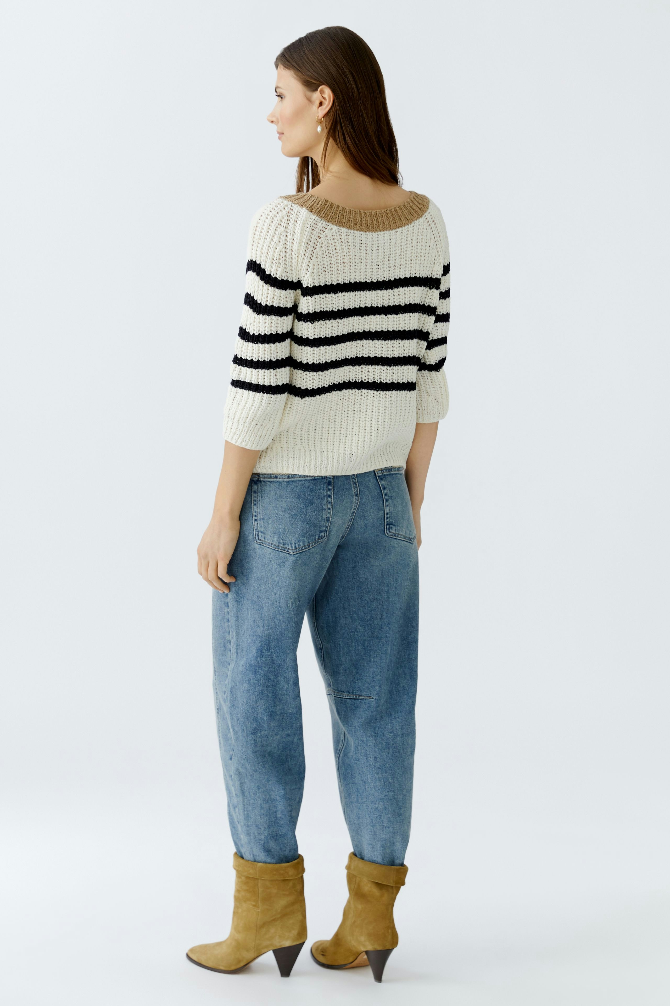 Casual women's pullover: A woman in a striped knit pullover with three-quarter sleeves and relaxed jeans.