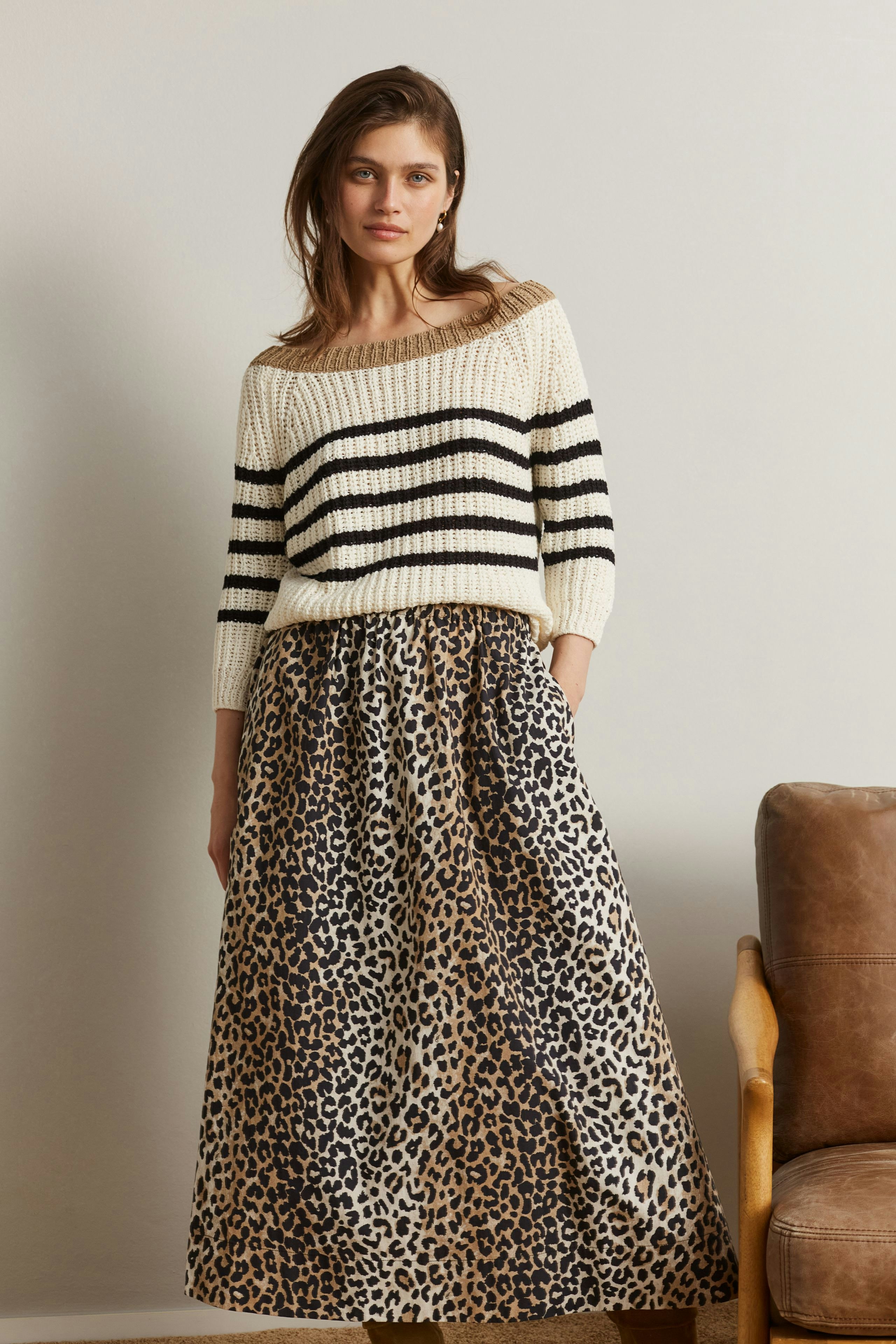 Casual women's pullover: A woman in a striped knit pullover paired with a leopard print skirt.