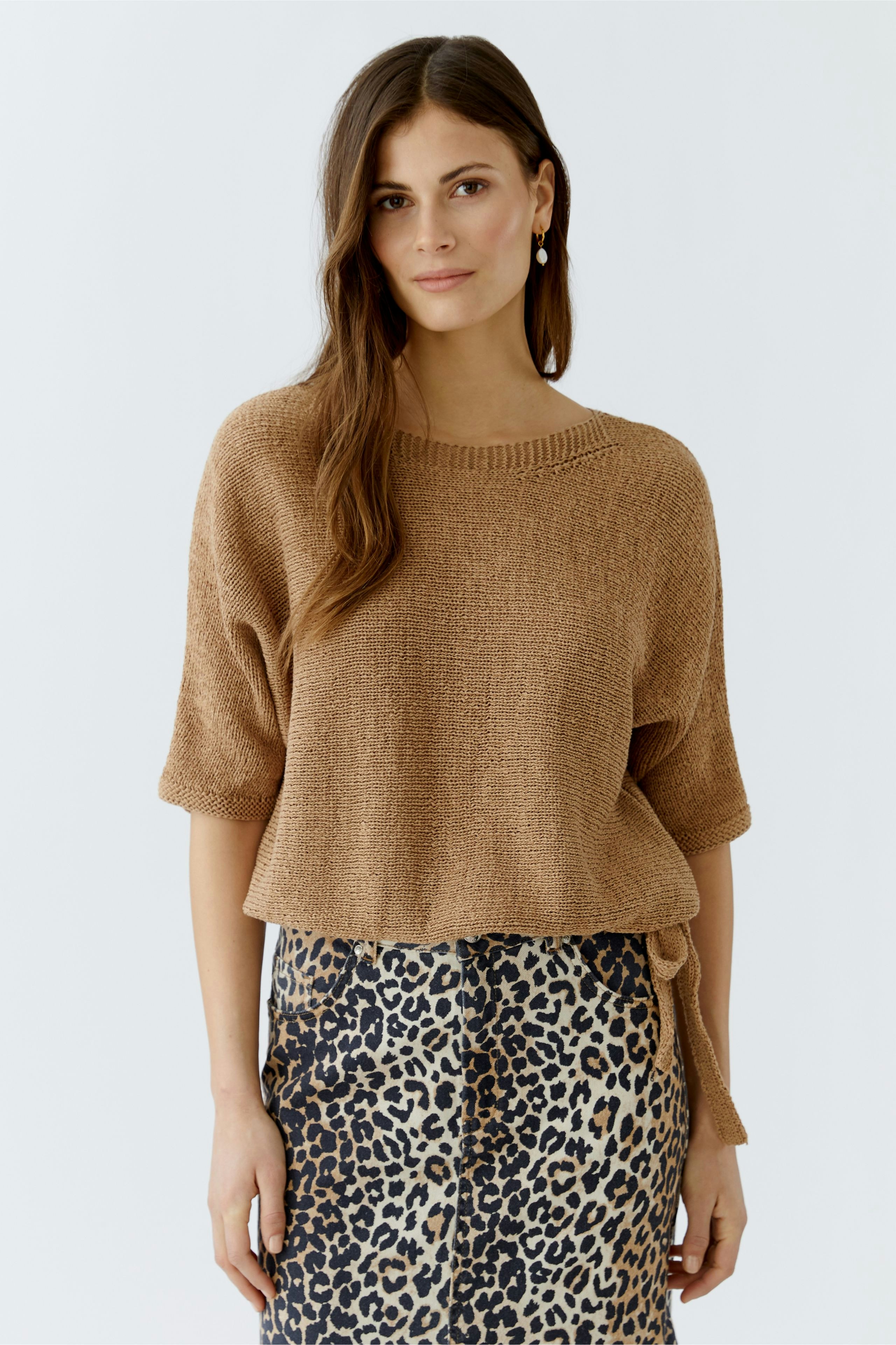 Casual women's pullover: A woman in a brown knit pullover paired with a leopard print skirt.
