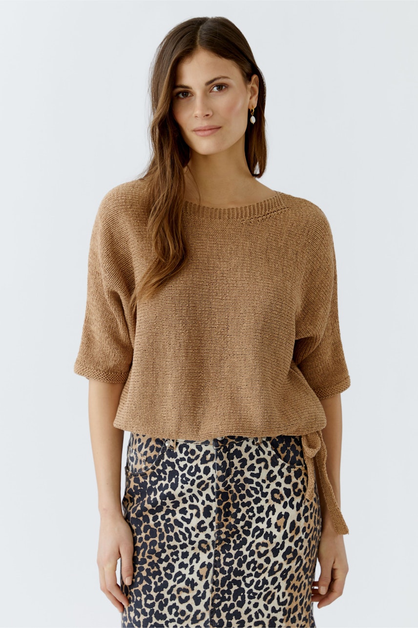 Damen-Pullover: Frau in braunem, lässigem Strickpullover mit kurzen Ärmeln und lockerer Passform.