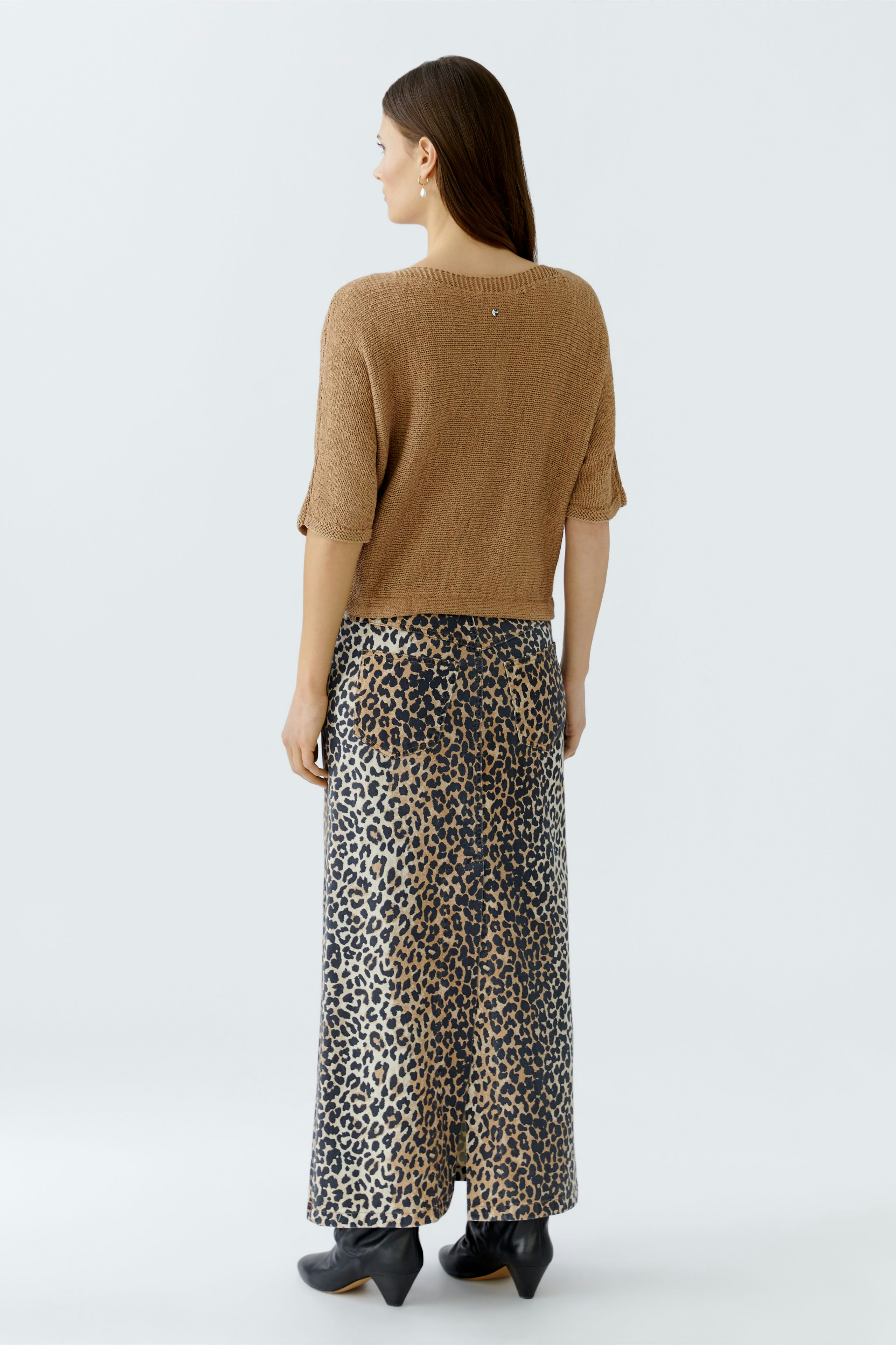Casual women's pullover: A woman in a short-sleeved brown pullover paired with a leopard print skirt.