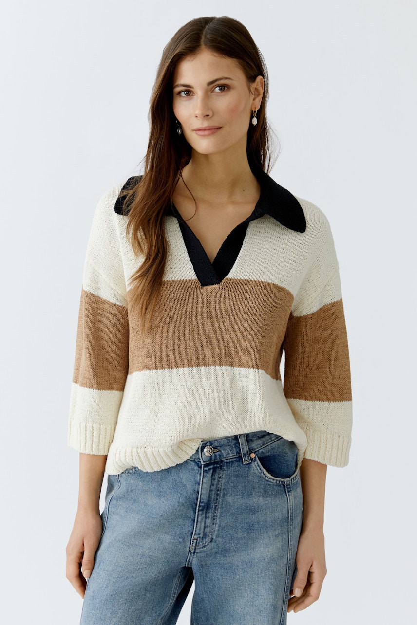 Damen-Pullover: Junge Frau in einem gestreiften Pullover mit Kragen und lässigen Jeans.