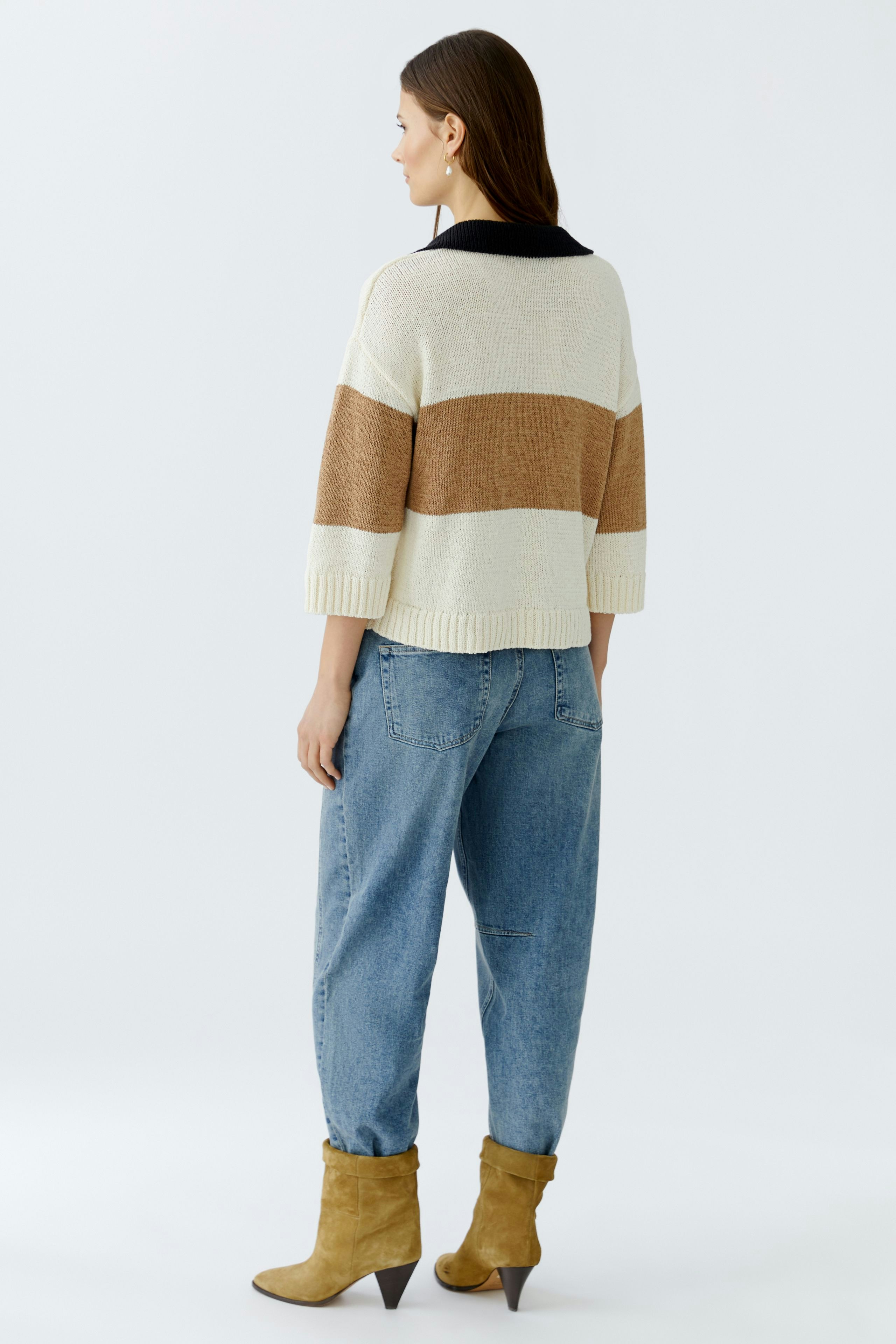 Casual women's pullover: A woman in a striped pullover with a relaxed fit, paired with loose jeans.