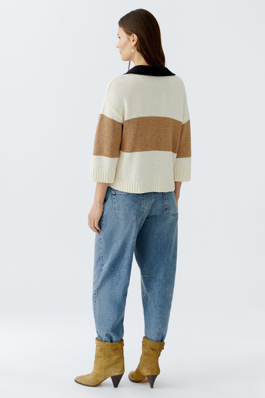 Damen-Pullover: Frau mit gestreiftem Pullover in Beige und Braun, kombiniert mit lässigen Jeans.