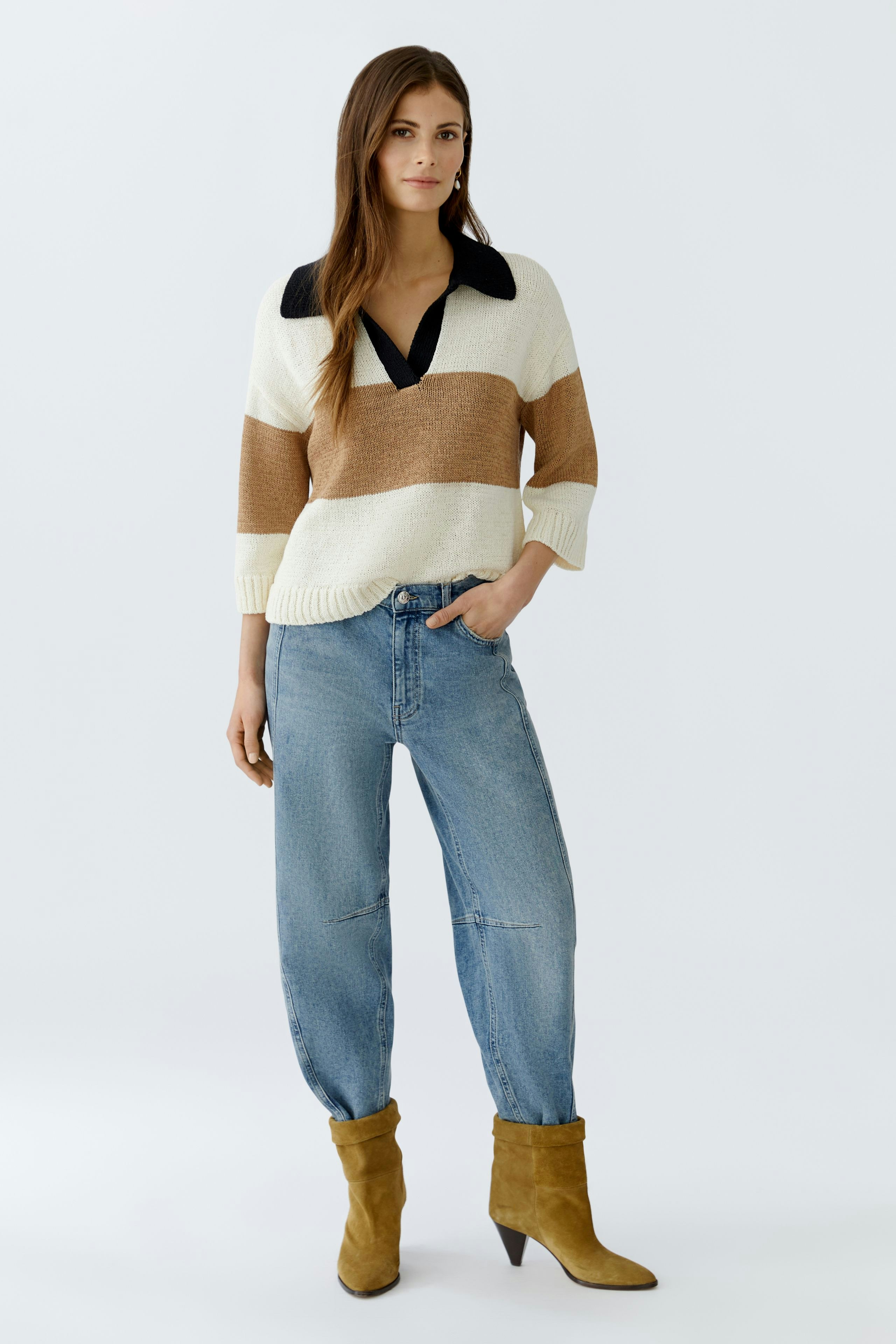 Casual women's pullover: A woman in a striped pullover with a collar and relaxed jeans.