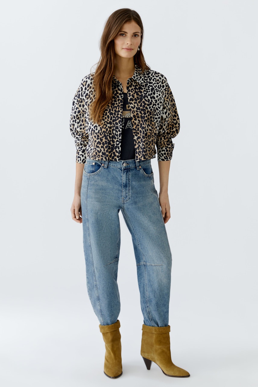 Casual women's jeans barrel: A woman in light blue jeans with a relaxed fit and a vibrant red top.