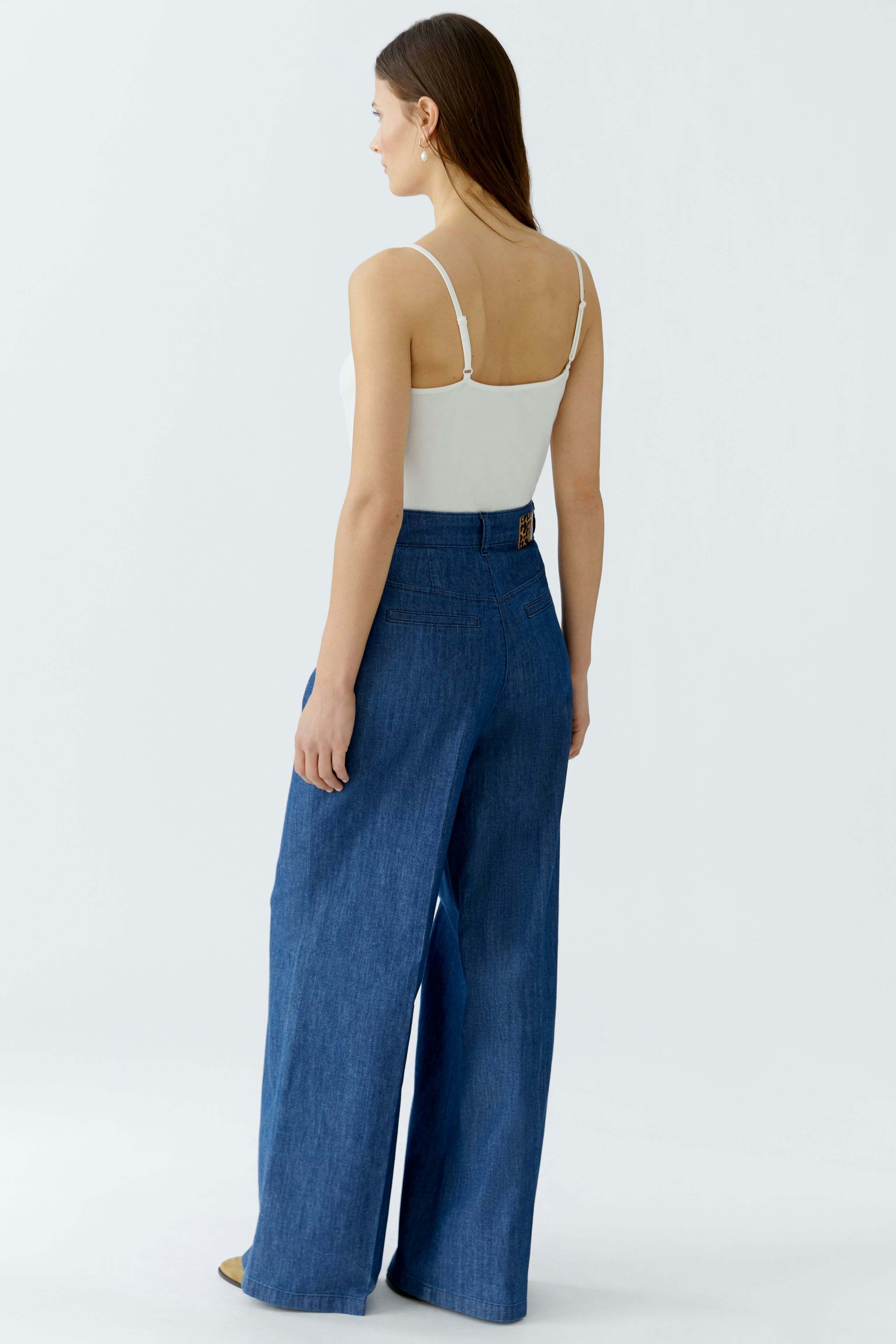 Wide-leg women's trousers: A woman in blue denim pants with a high waist and a relaxed fit.