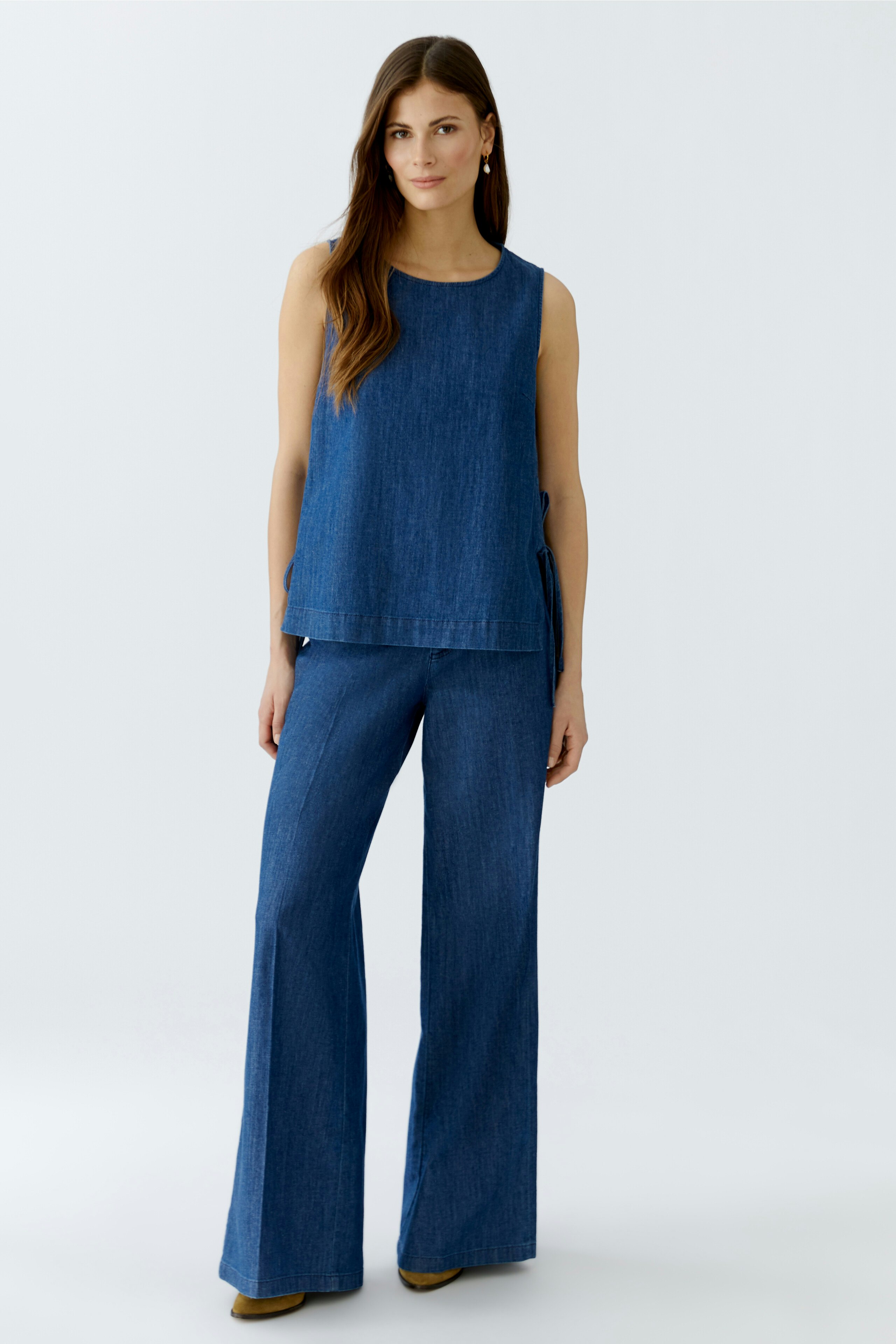 Casual women's pants: A woman in blue denim flared pants stands confidently against a light background.