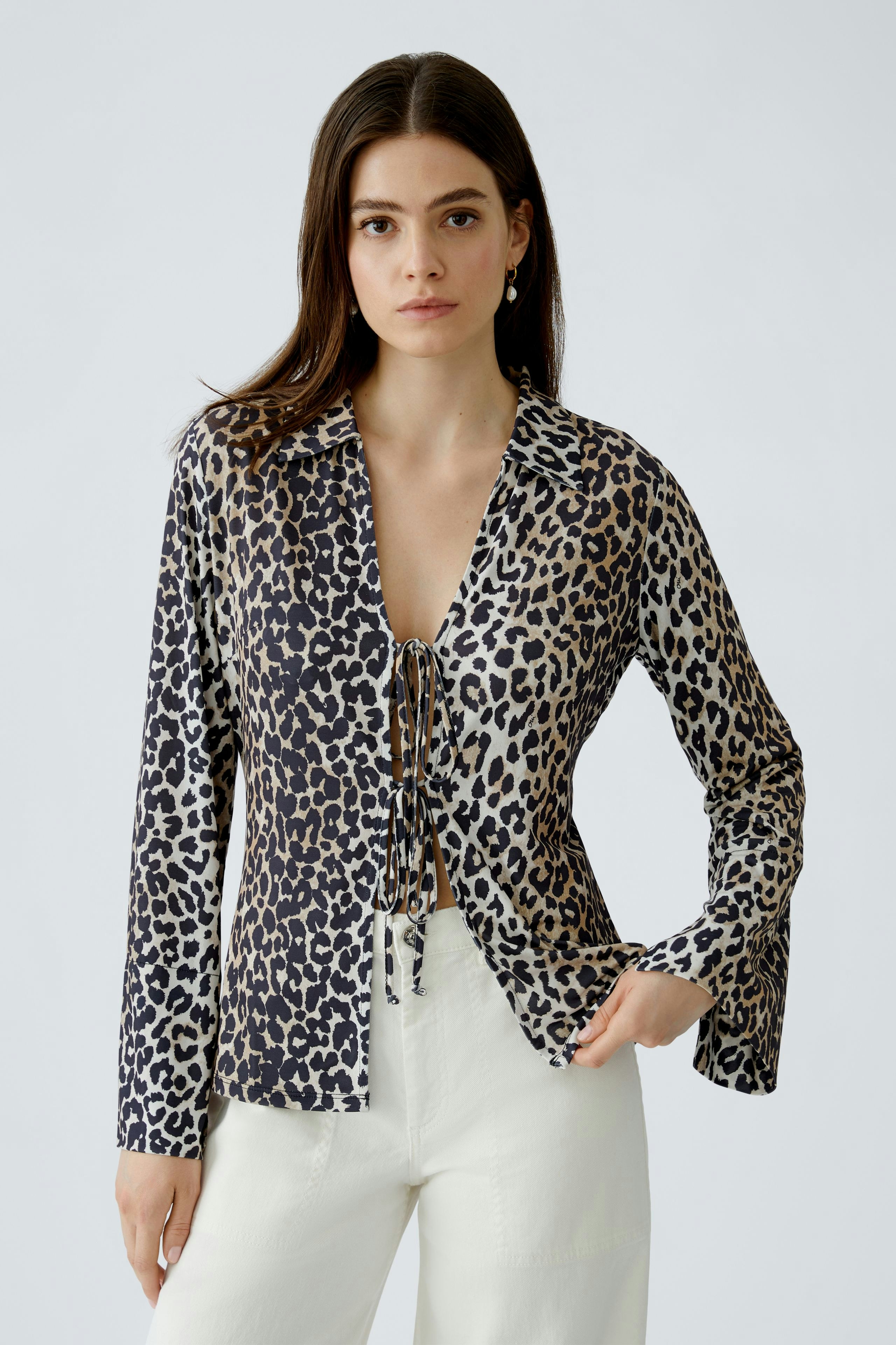Damen-Bluse im Leopardenmuster: Frau trägt eine lockere Bluse mit Schnürung und langen Ärmeln.