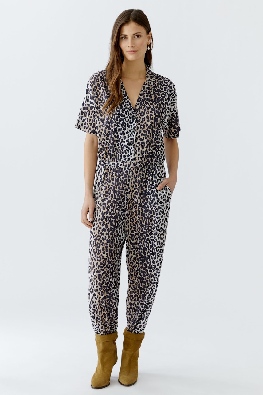 Bequemer Damen-Jumpsuit im Leo-Design: Frau trägt einen lässigen, gemusterten Jumpsuit mit kurzen Ärmeln.