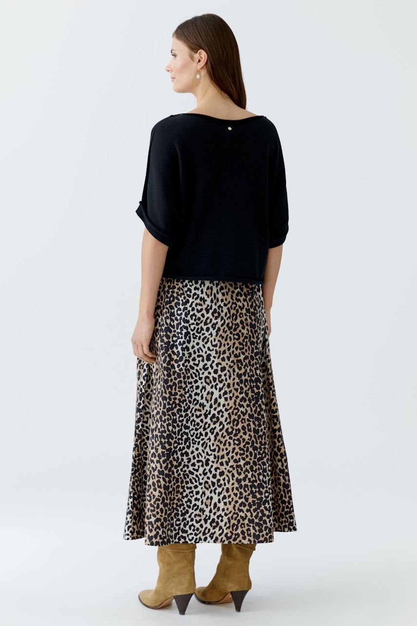 Damen-Pullover: Frau in schwarzem, lässigem Pullover mit weitem Schnitt und animalischem Rock.