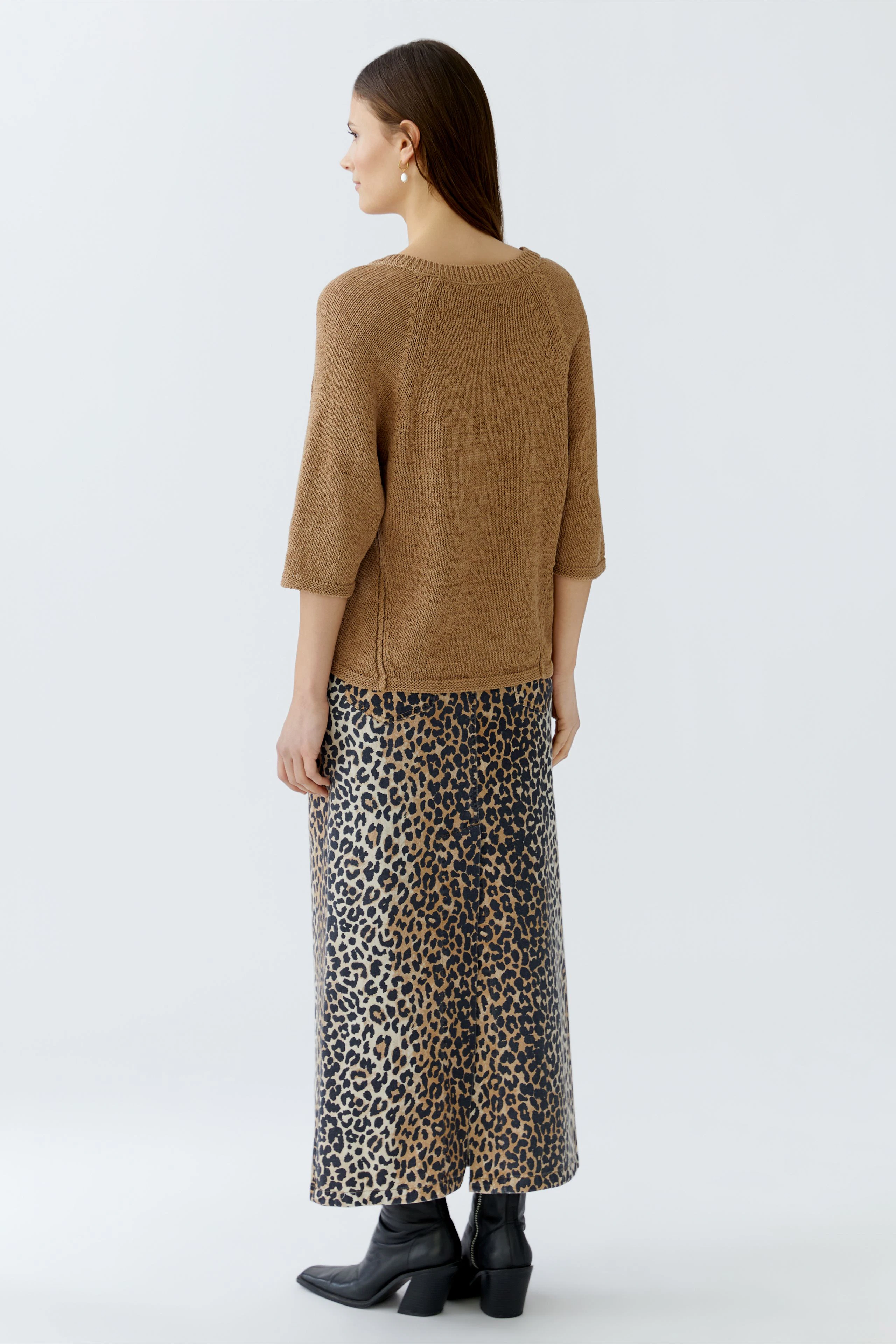 Casual women's pullover: A woman in a brown knit pullover with three-quarter sleeves, paired with a leopard print skirt.