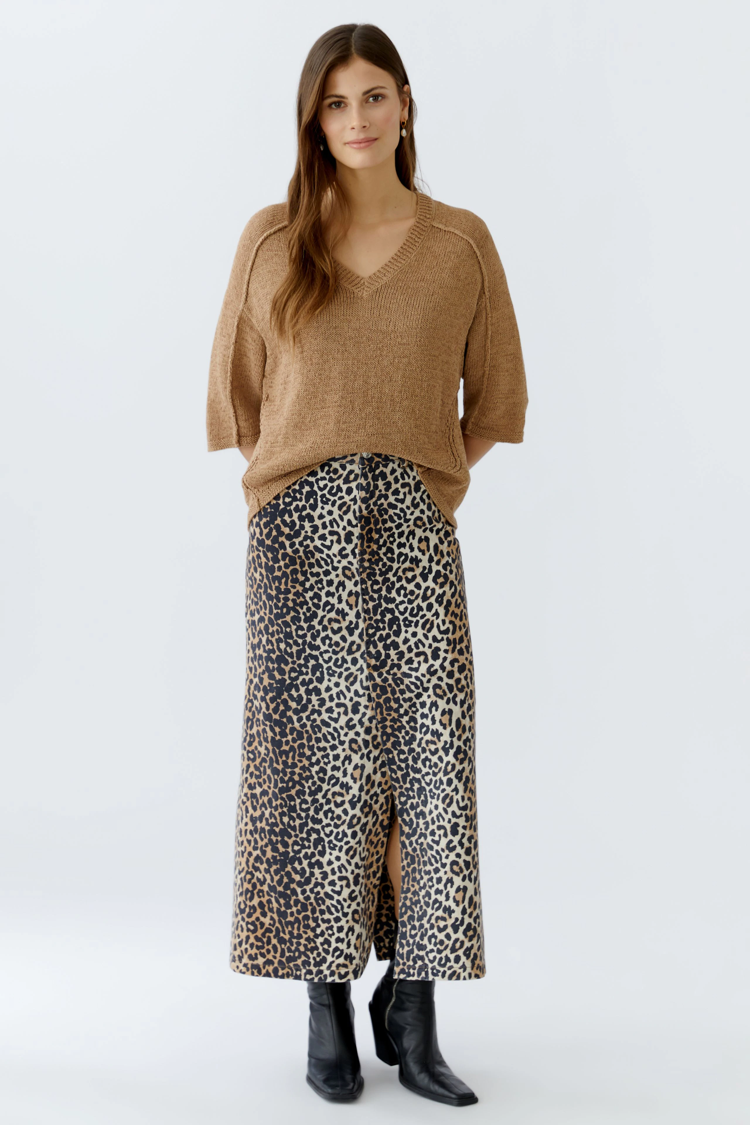 Casual women's pullover: Young woman in a brown knit pullover paired with a leopard print skirt.
