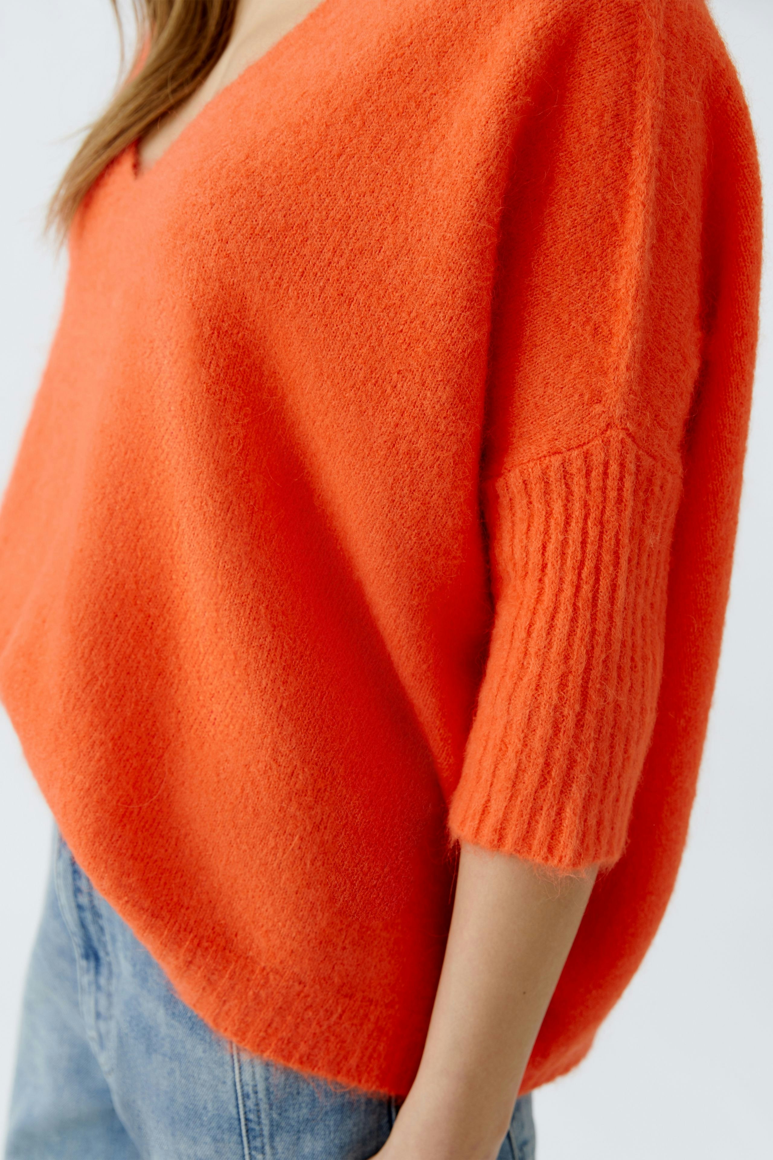 Casual women's pullover in vibrant orange with a relaxed fit and ribbed sleeves.