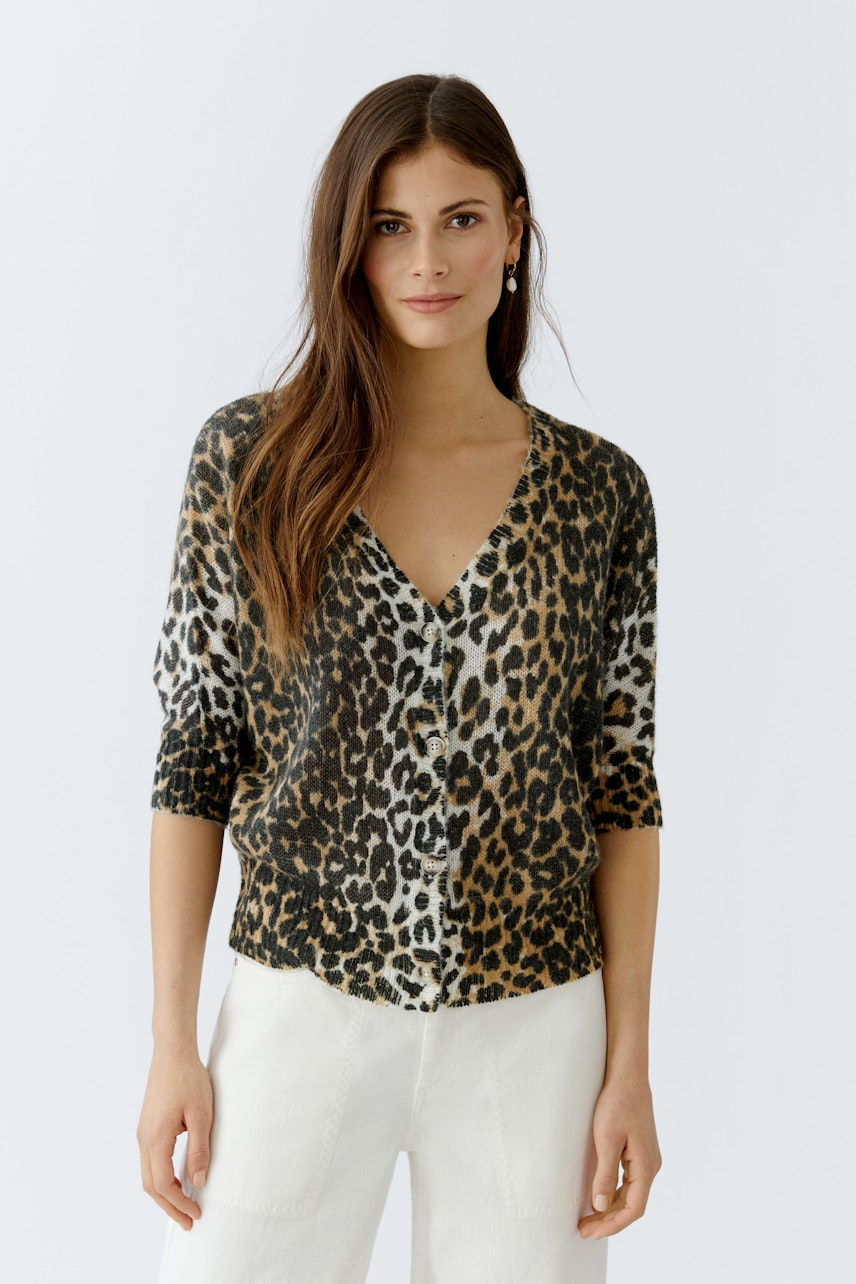 Casual women's cardigan: A woman in a leopard print cardigan with a V-neck and short sleeves.
