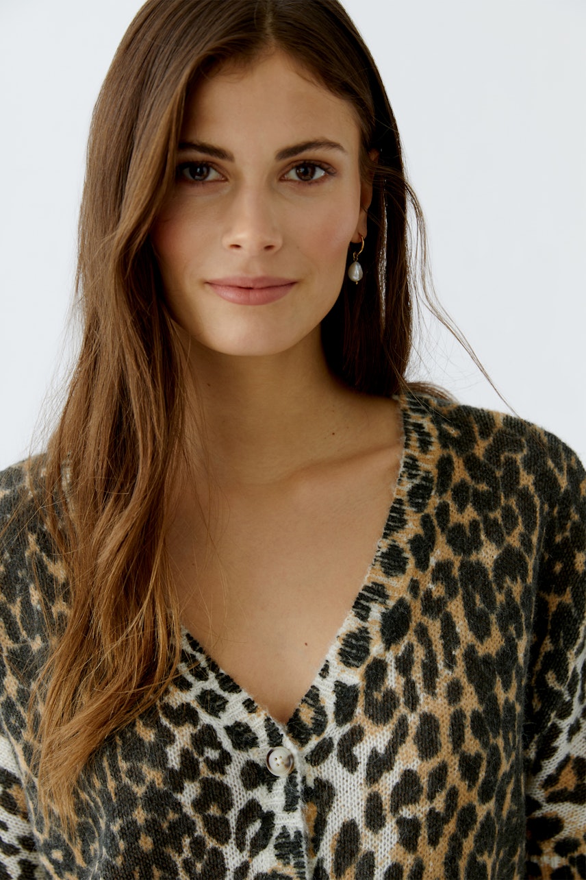 Casual women's cardigan: A woman in a leopard print cardigan with a deep V-neck and buttons.