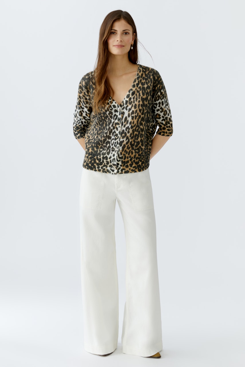 Casual women's cardigan: A woman in a leopard print cardigan with a V-neck and relaxed fit.