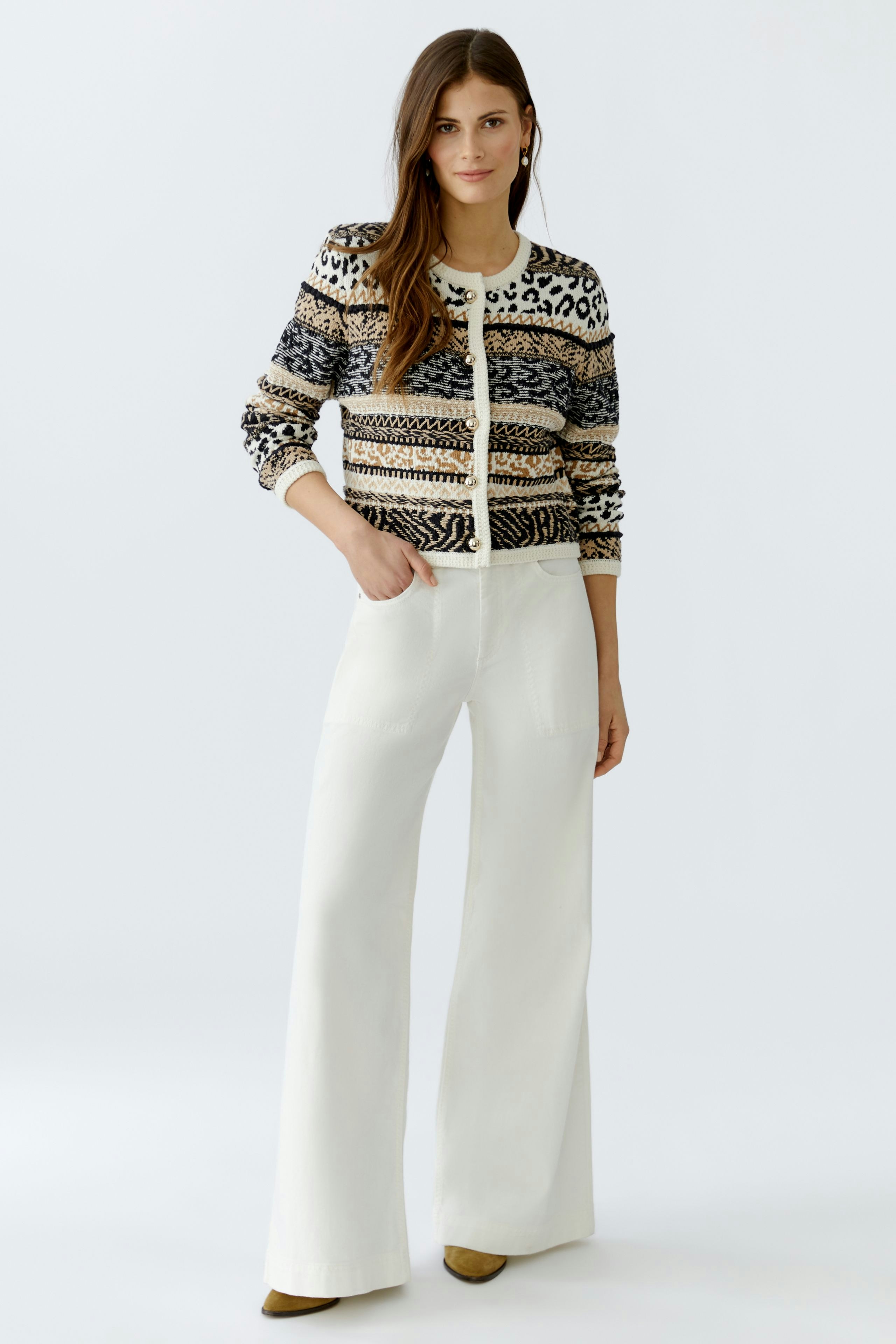 Casual women's cardigan: A woman in a patterned knit cardigan with wide-leg pants, looking relaxed.