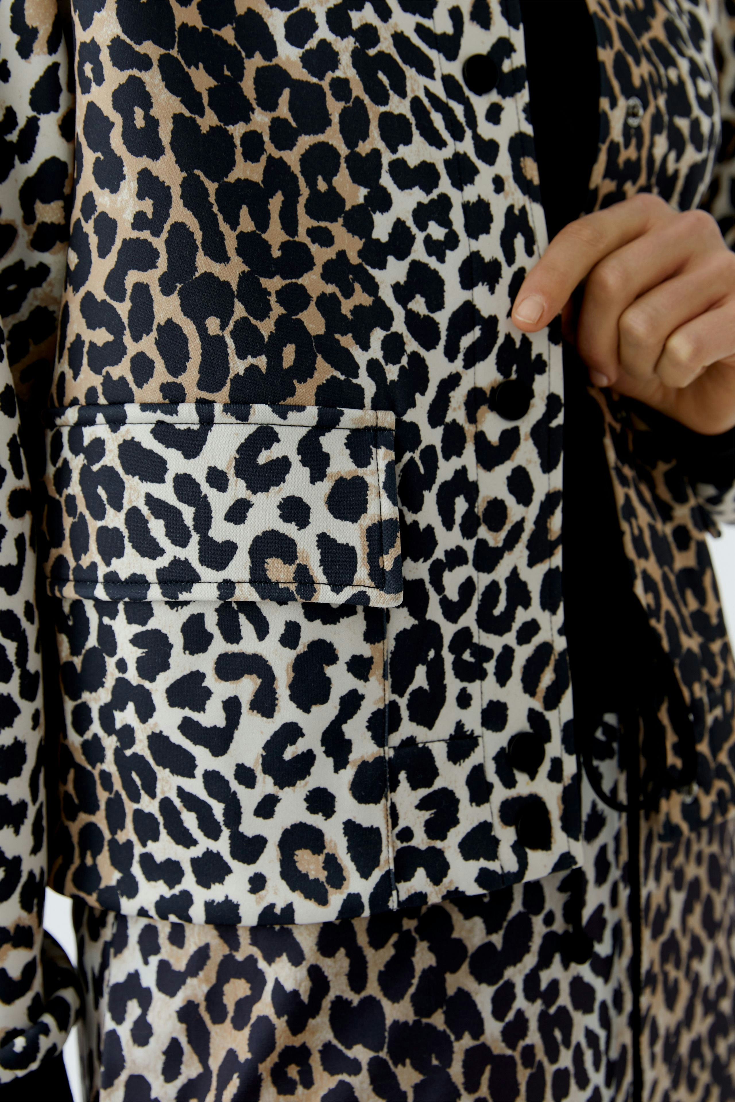 Stylish women's blouson: Close-up of a leopard print jacket with a pocket, showcasing a trendy design.