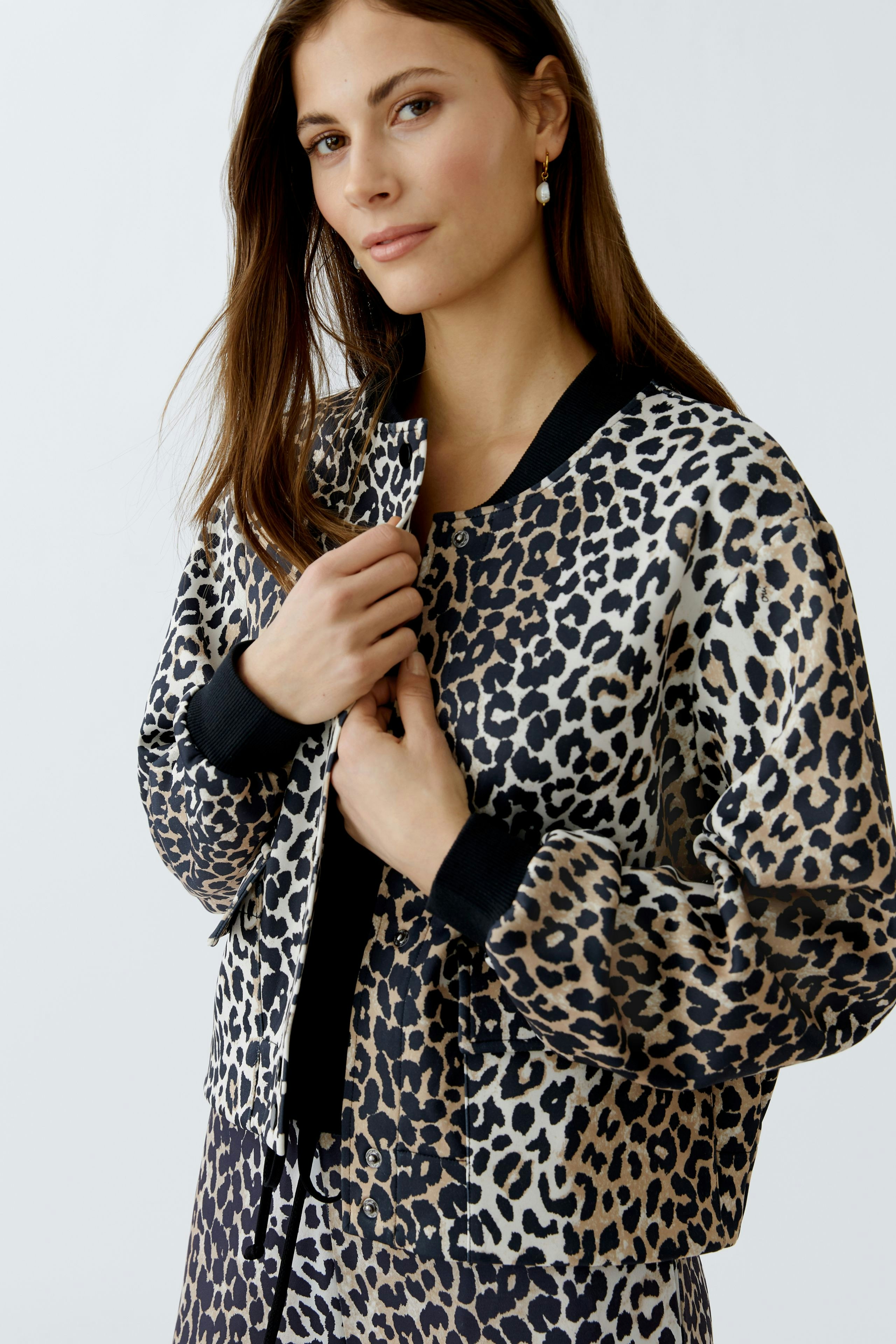 Modern women's blouson: A woman in a stylish leopard print bomber jacket, exuding confidence.