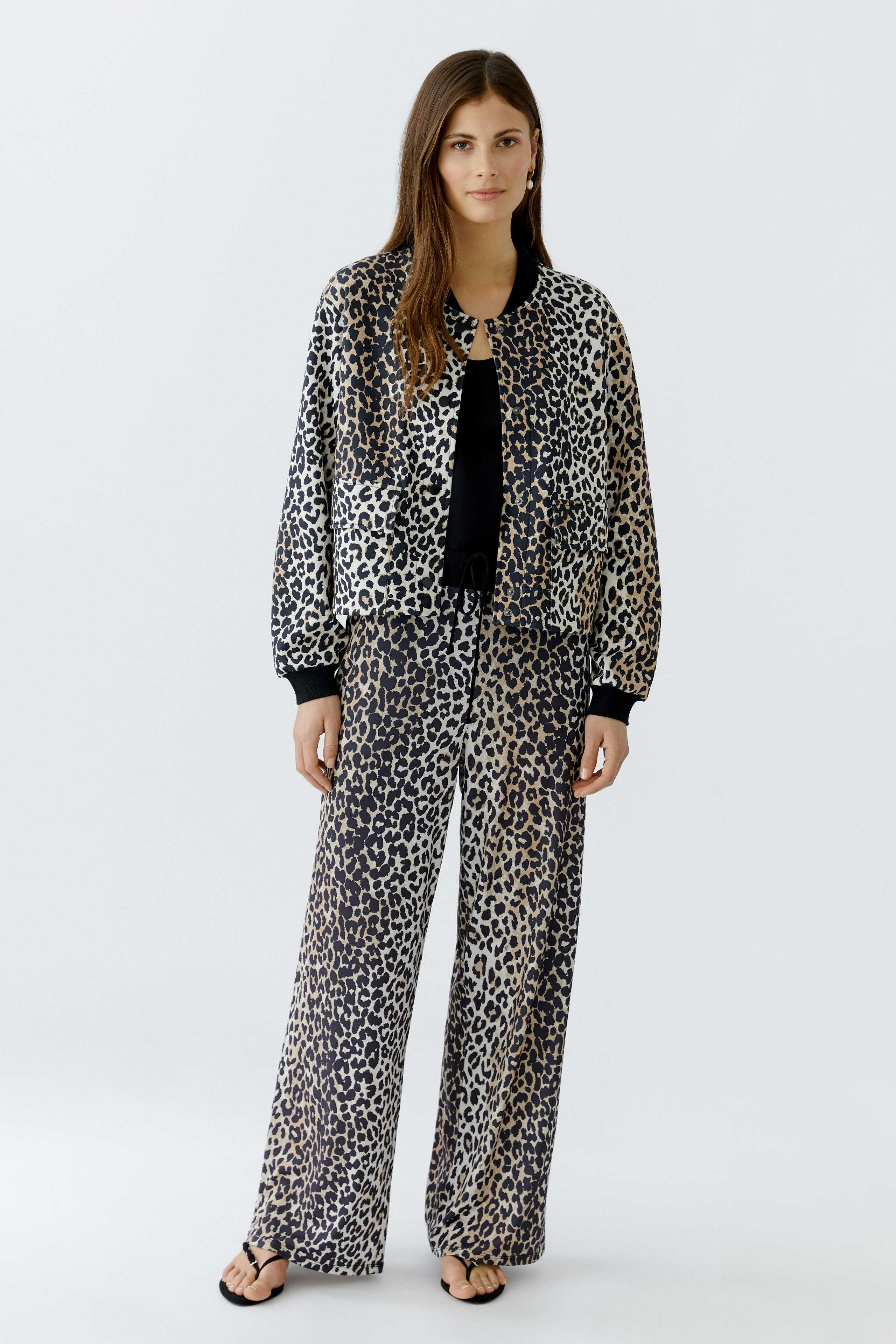 Stylish women's blouson: A woman in a leopard print bomber jacket paired with matching pants.