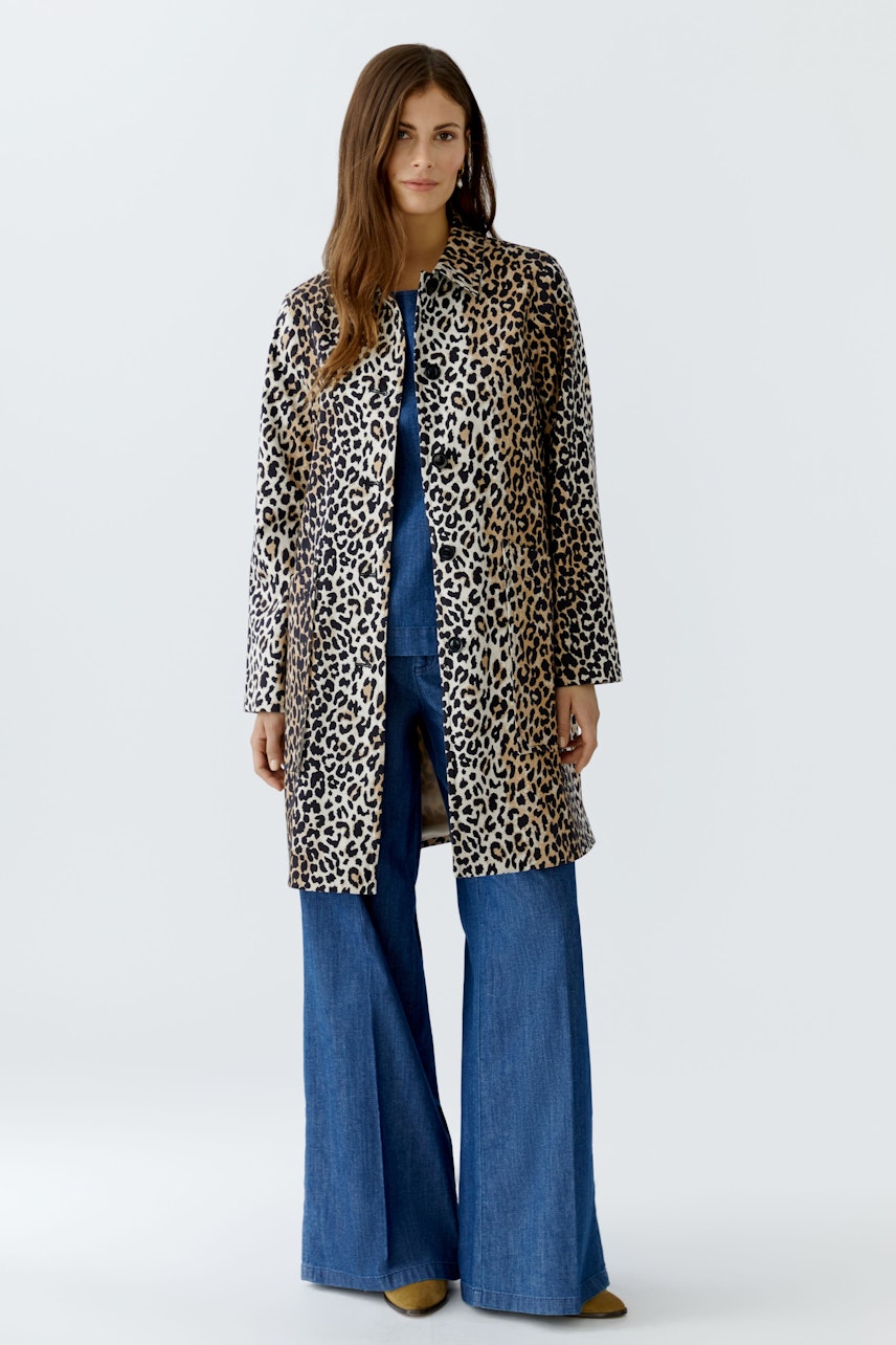 Stylish women's coat: A woman in a leopard print coat paired with wide-leg jeans.