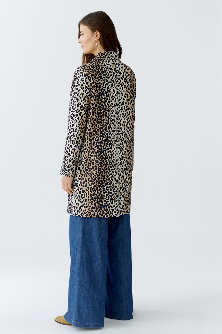 Stylish women's coat: A woman in a leopard print coat paired with wide-leg jeans.