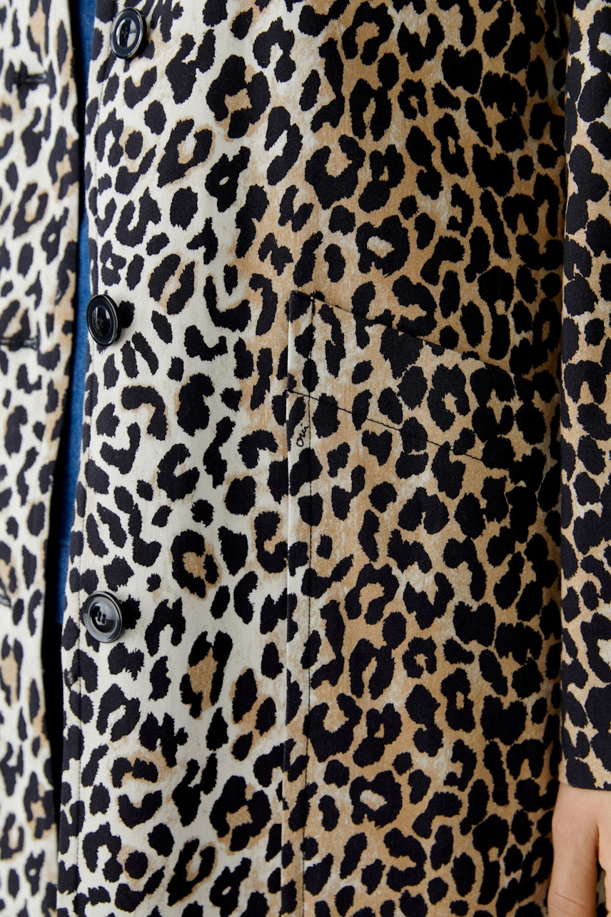 Leopard print coat: A woman wearing a stylish coat with a bold leopard pattern and practical pockets.