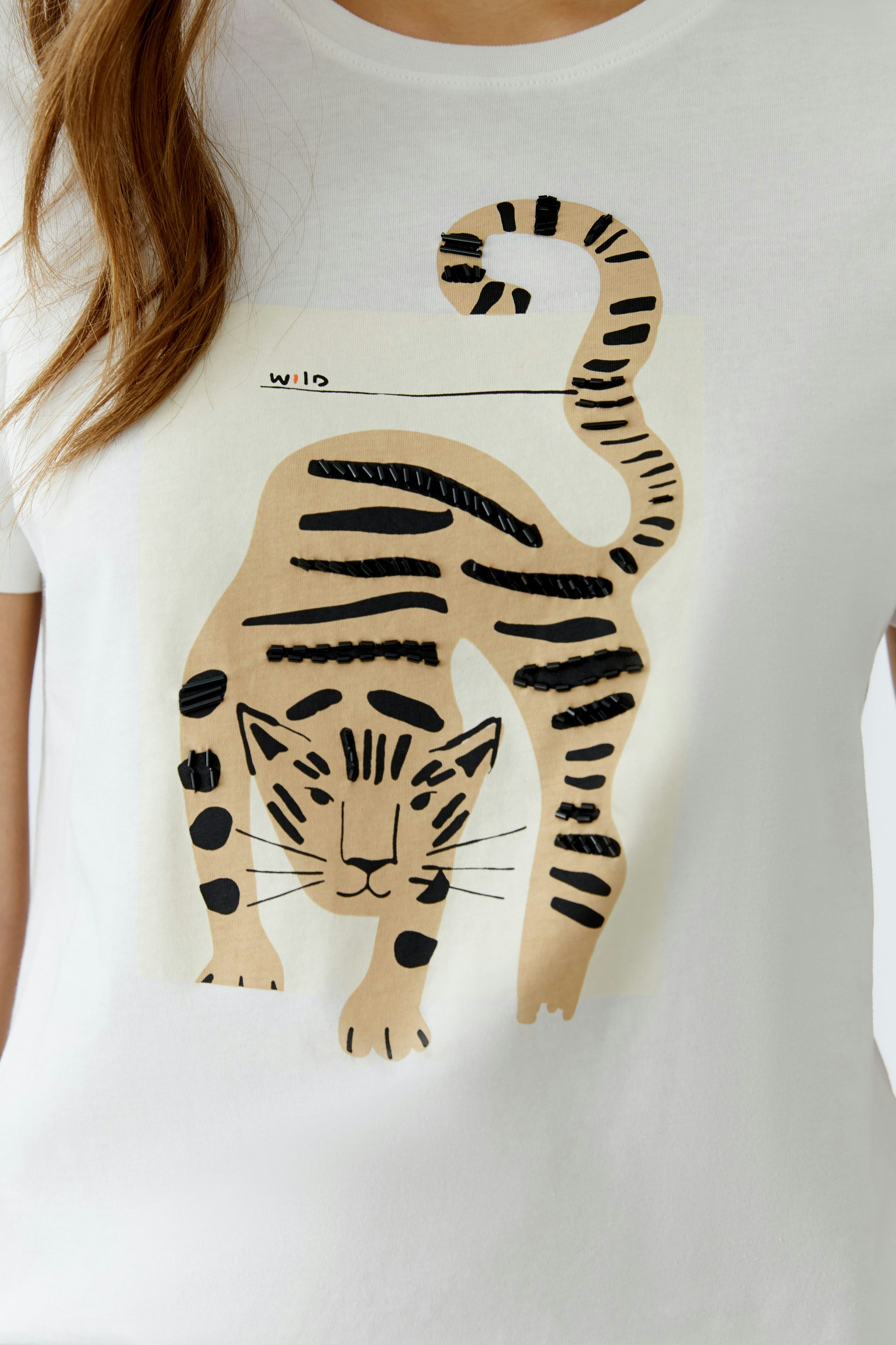 Casual women's T-shirt featuring a playful tiger graphic in black and beige.
