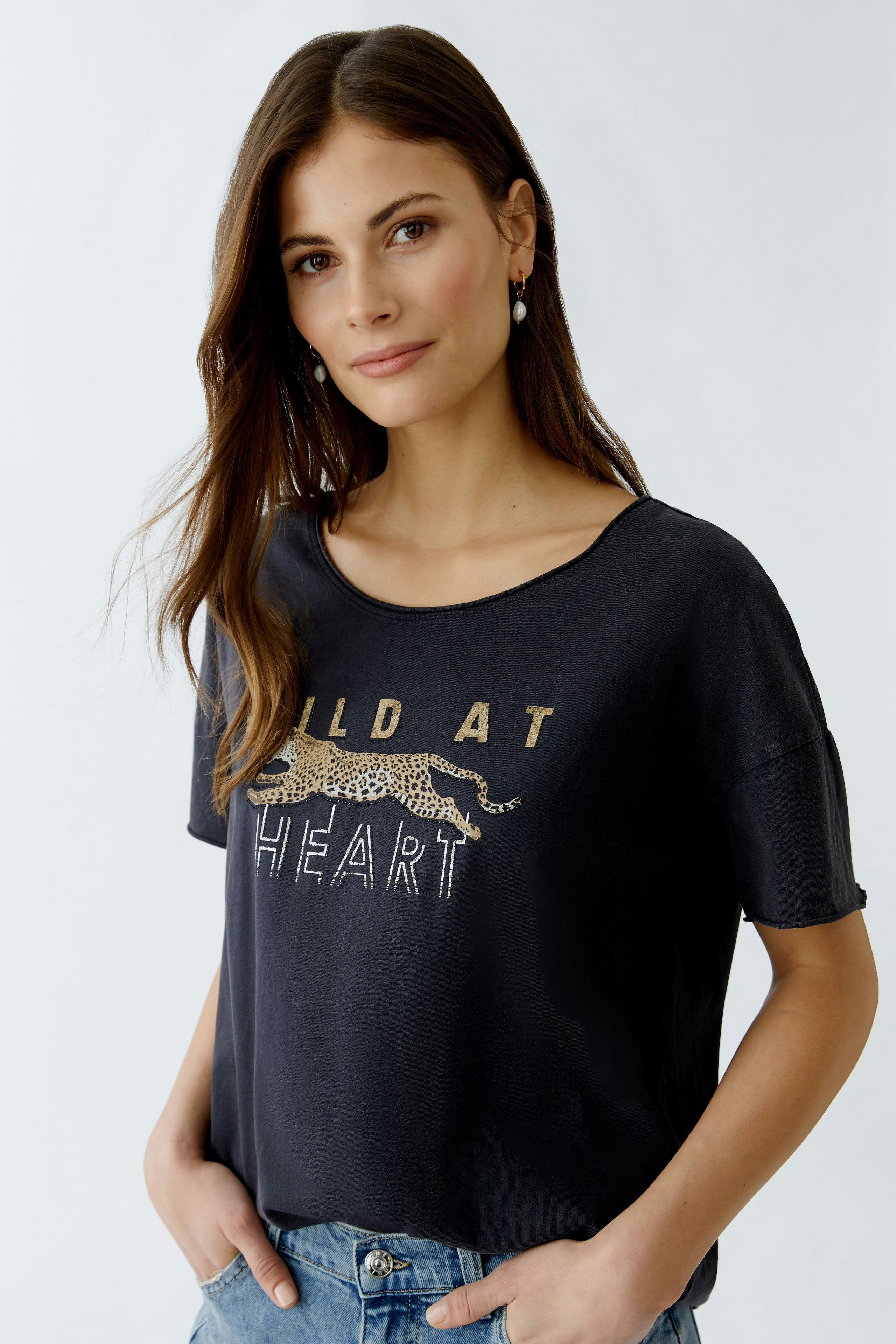 Casual women's T-shirt: Young woman in a black tee with a leopard print and bold lettering.