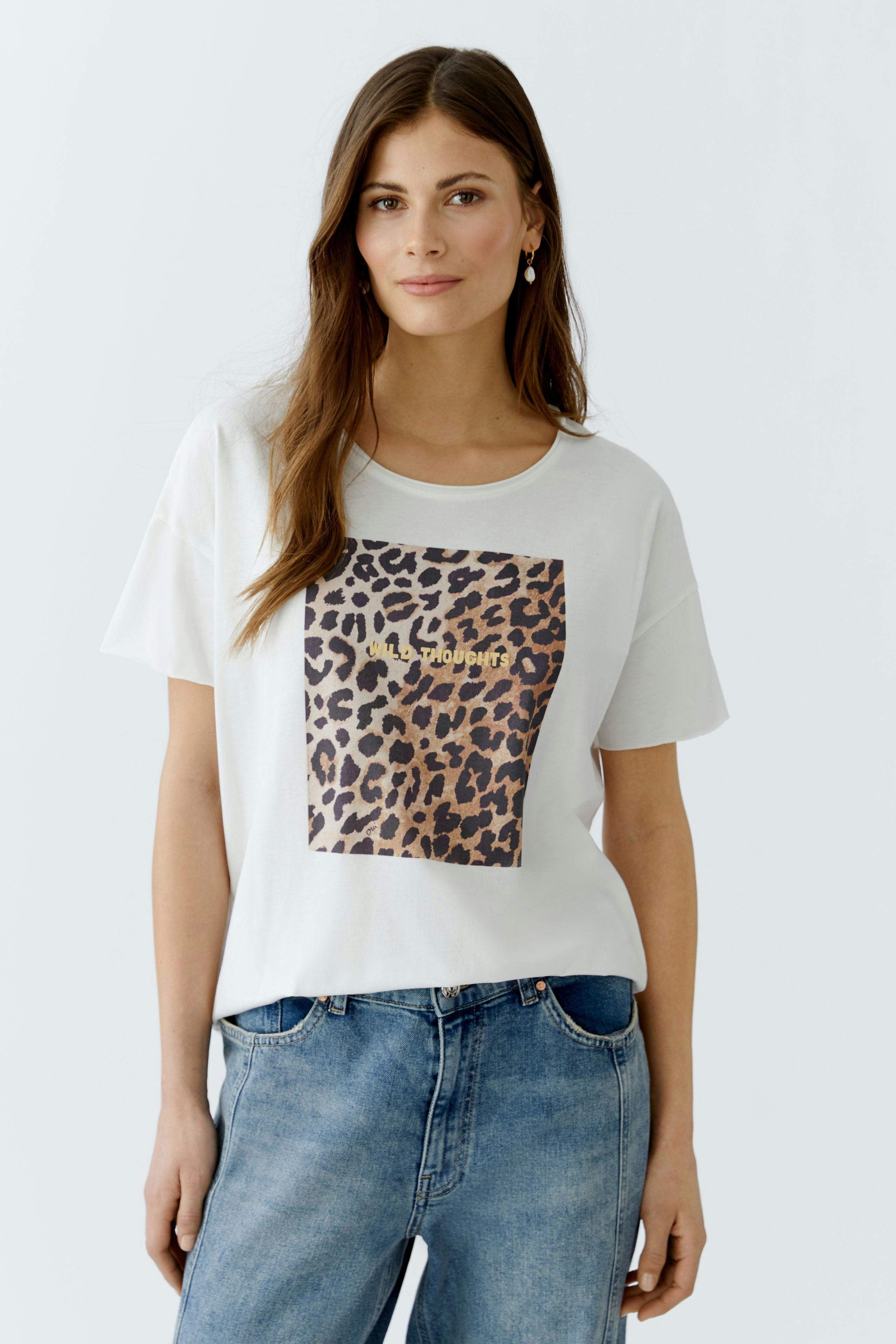 Casual women's T-shirt: Young woman in a white tee with a leopard print design and relaxed fit.