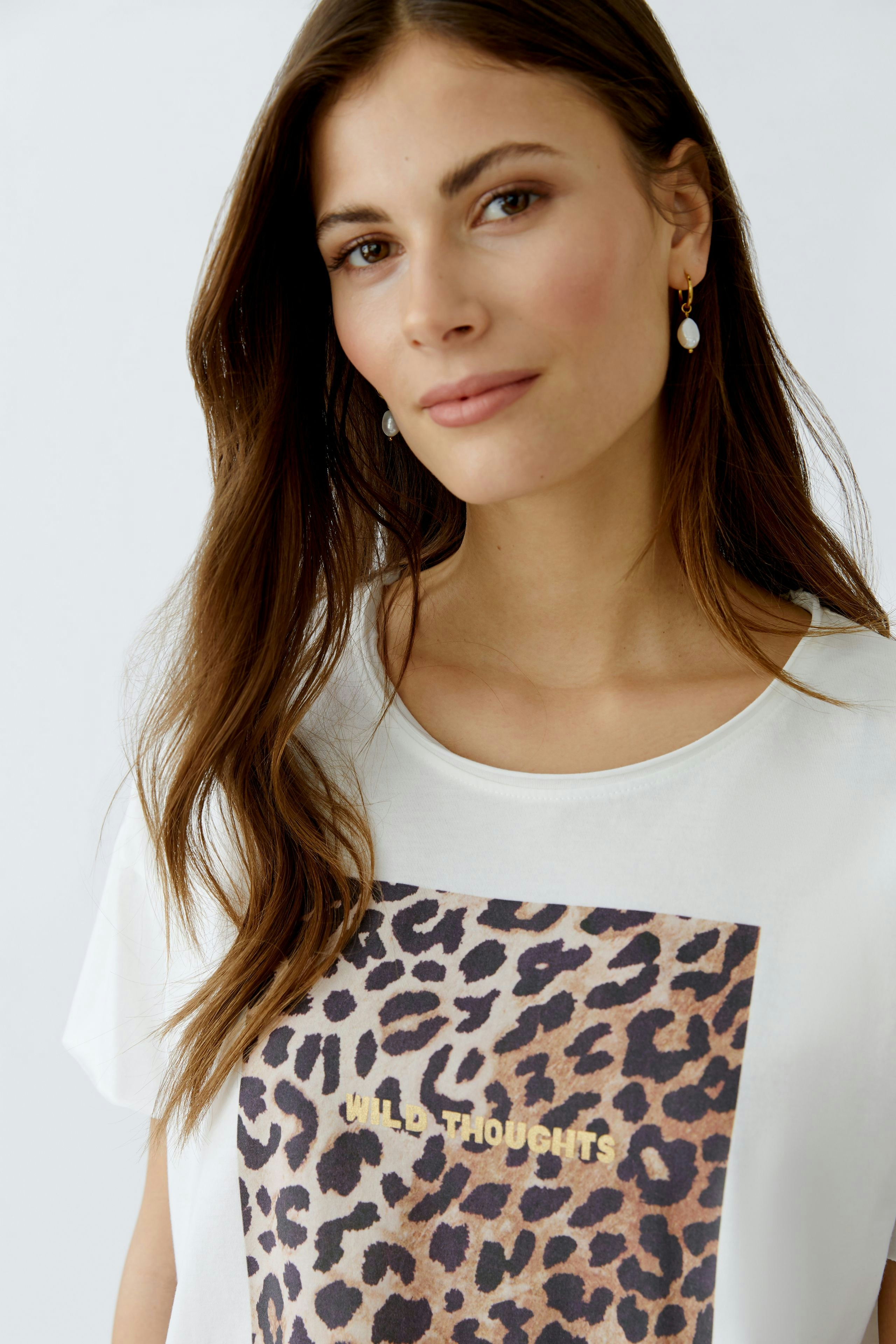 Casual women's T-shirt: Young woman in a white tee with a leopard print and gold lettering.