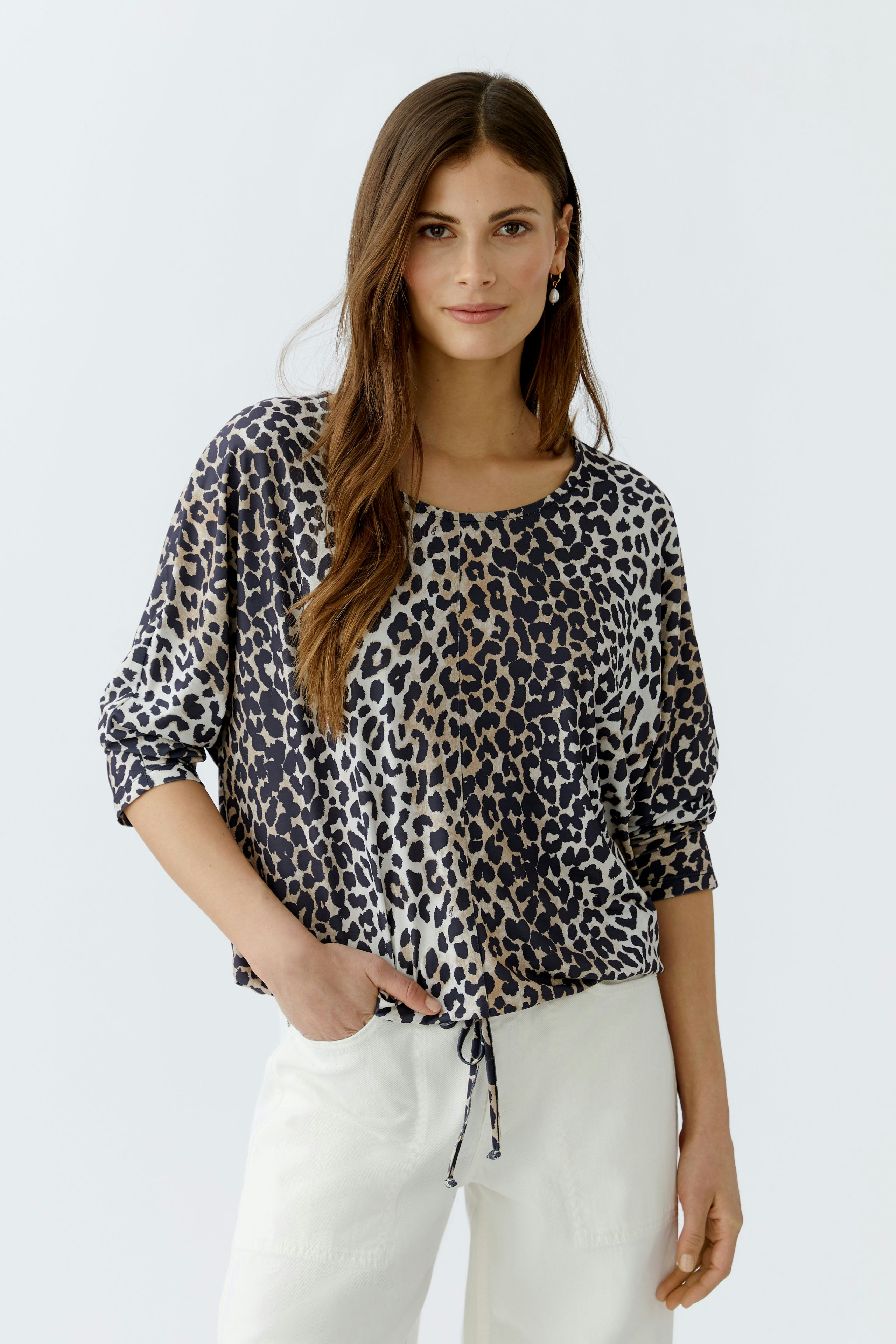 Casual women's blouse: A woman in a leopard print blouse with a relaxed fit and drawstring detail.