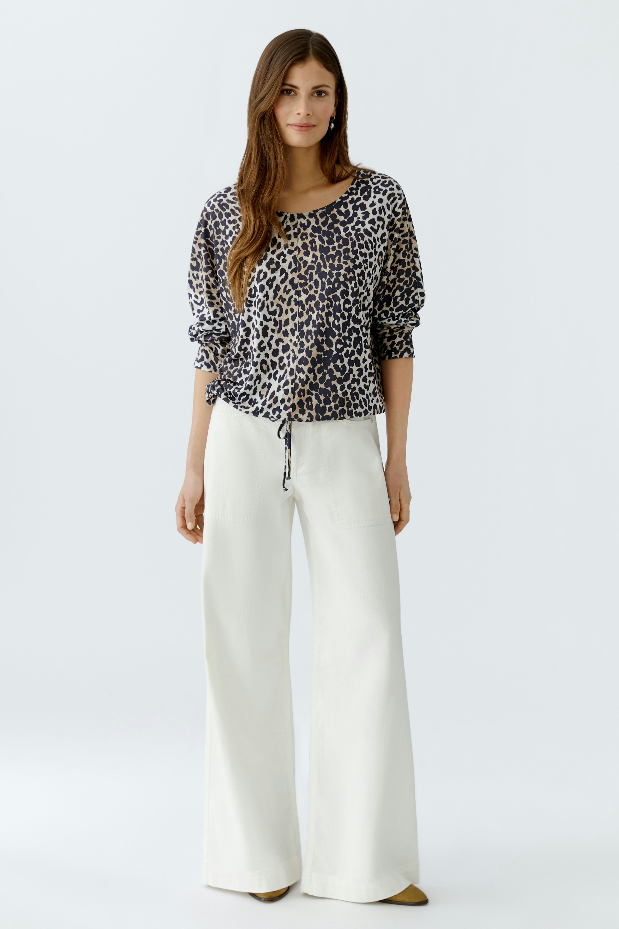 Casual women's blouse: A woman in a leopard print blouse with a relaxed fit and drawstring detail.