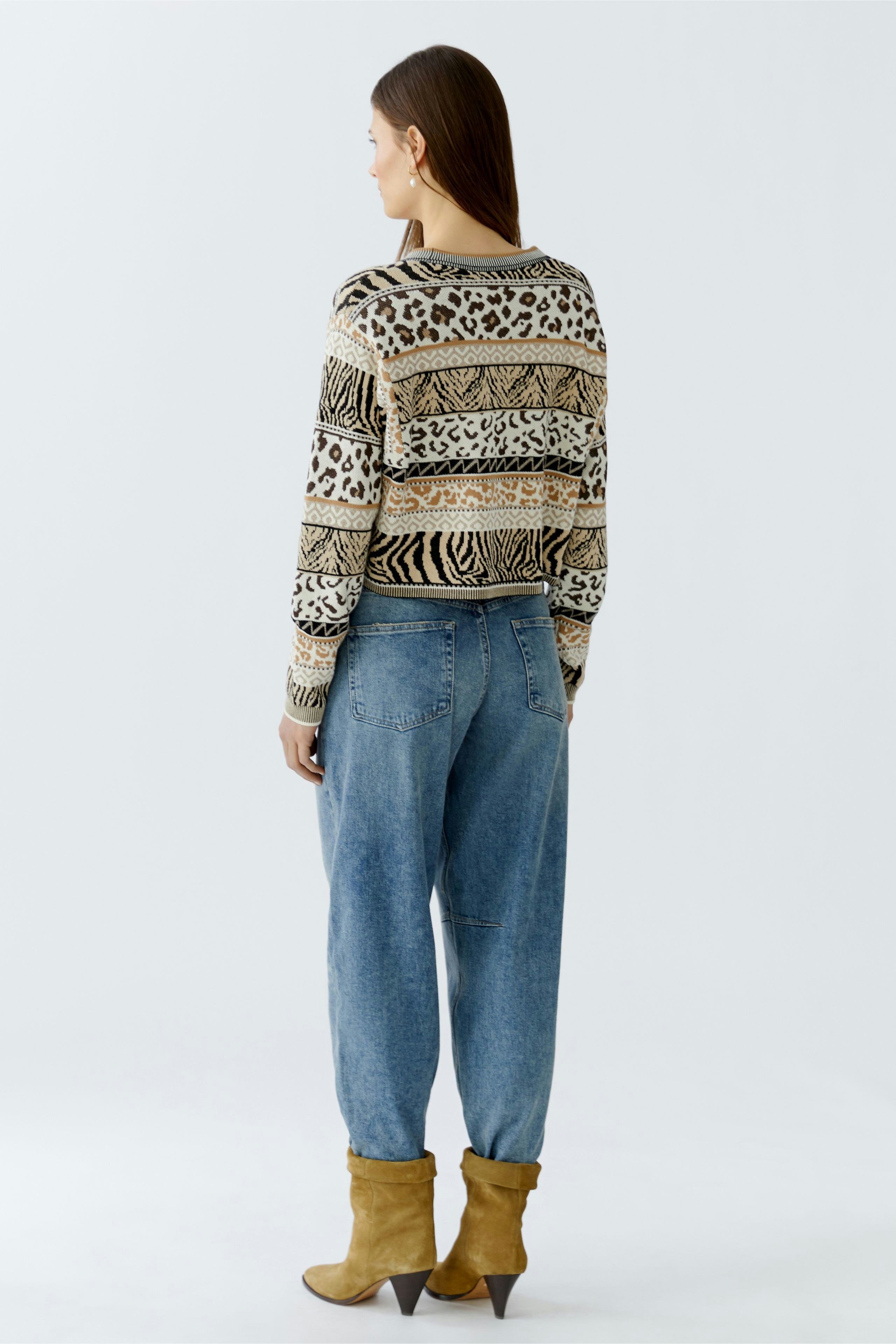 Damen-Pullover mit animalischem Muster, lässig kombiniert mit Jeans und Stiefeln, von hinten sichtbar.