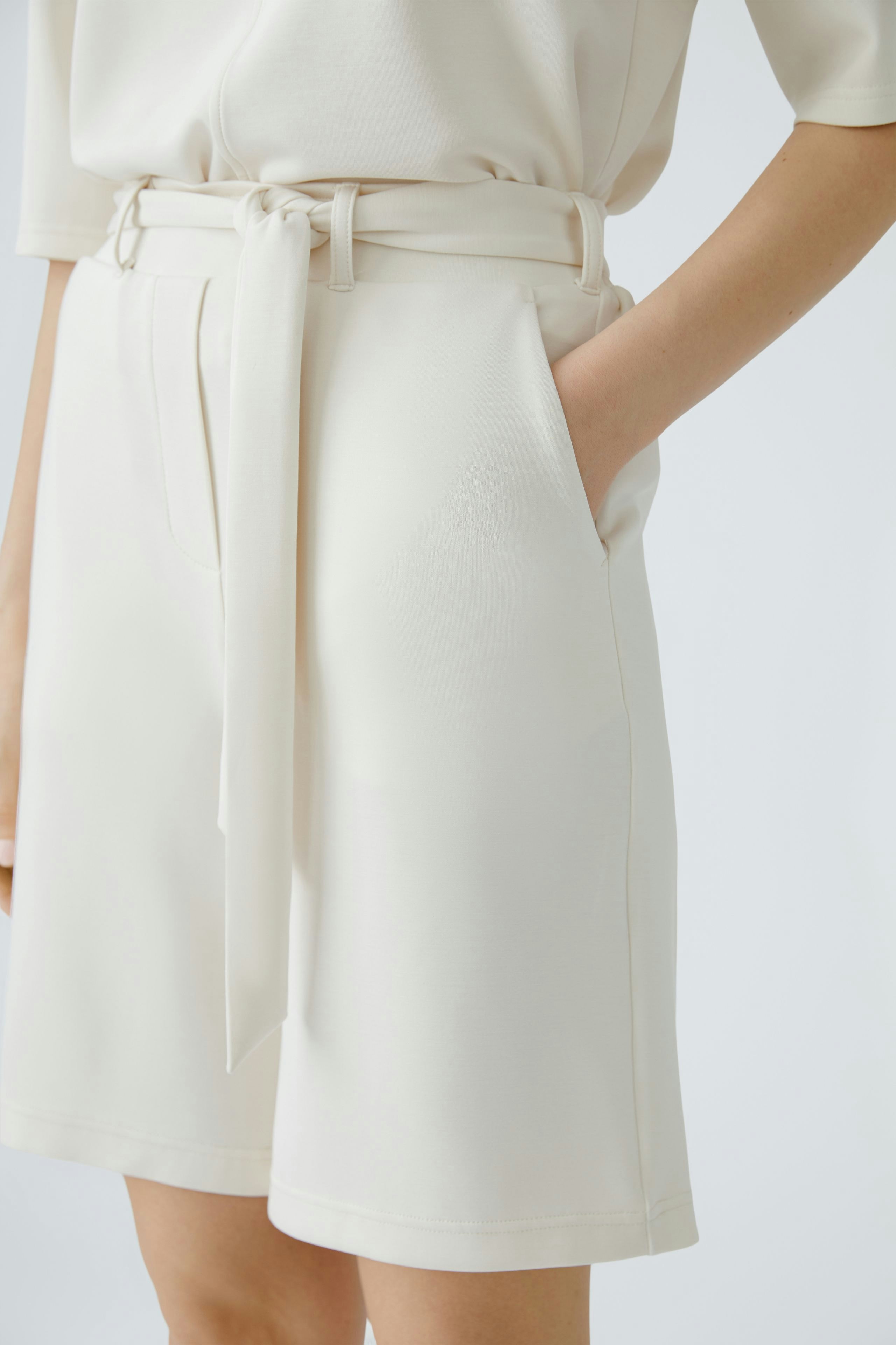 Bequeme Damen-Bermuda in Creme mit Gürtel und Taschen, ideal für lässige Sommerlooks.