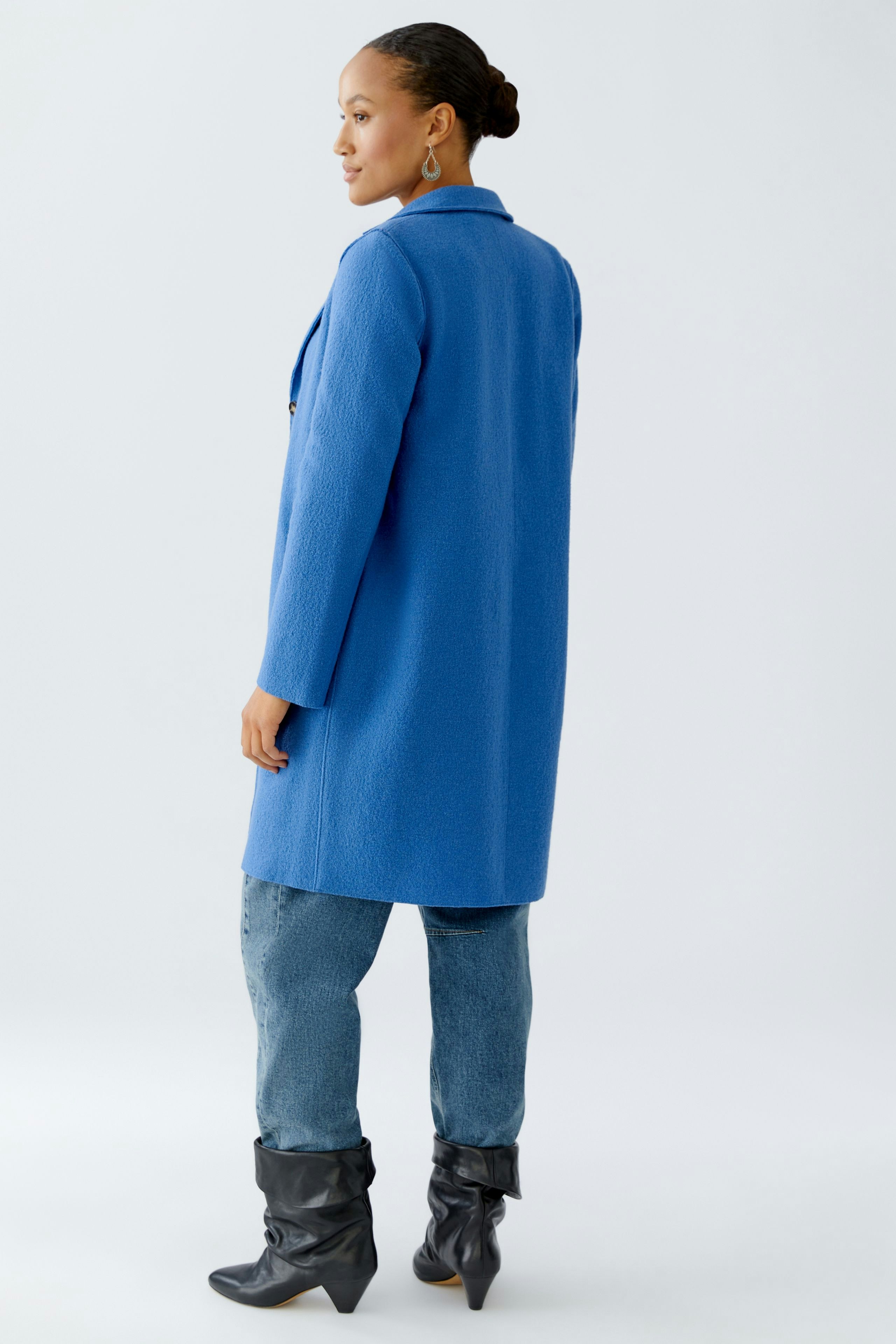 Stylish women's wool coat in vibrant blue, paired with casual jeans and knee-high boots.