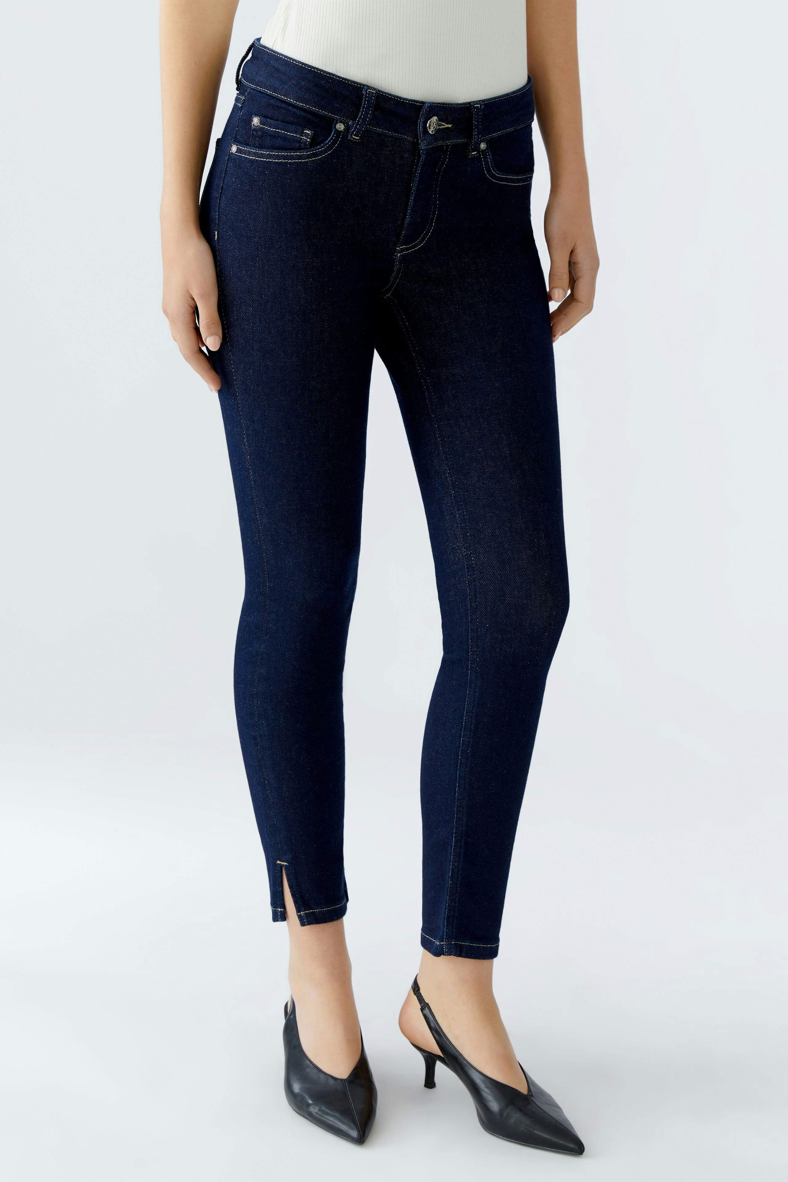 Skinny jeans for women: A woman in dark blue skinny jeans with a fitted silhouette and stylish ankle detail.