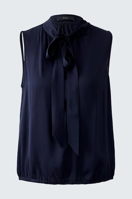 Sleeveless blouse: A woman in a navy top with a bow tie detail, perfect for casual outings.