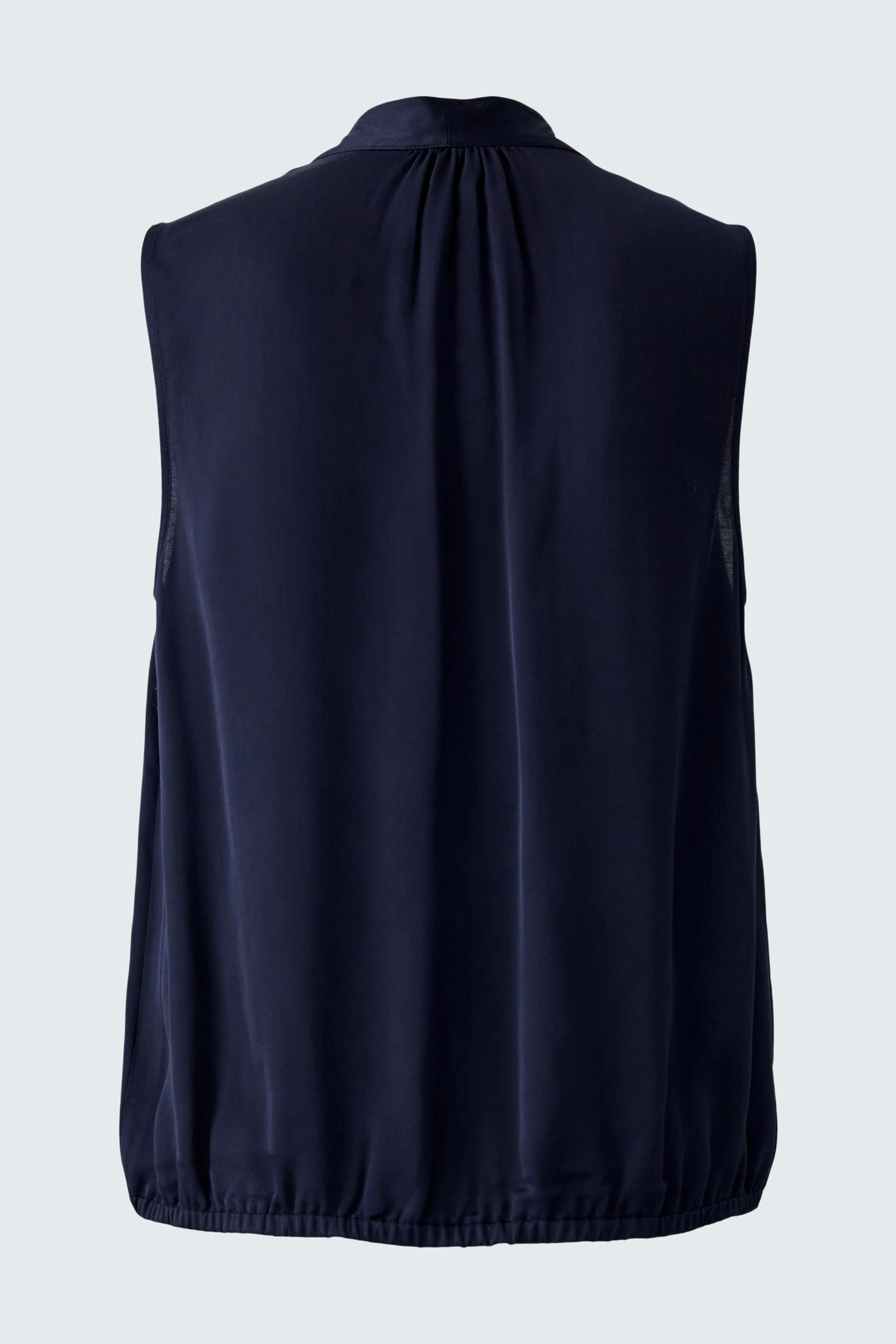 Sleeveless blouse: A woman in a navy blue sleeveless blouse with a relaxed fit, perfect for casual wear.