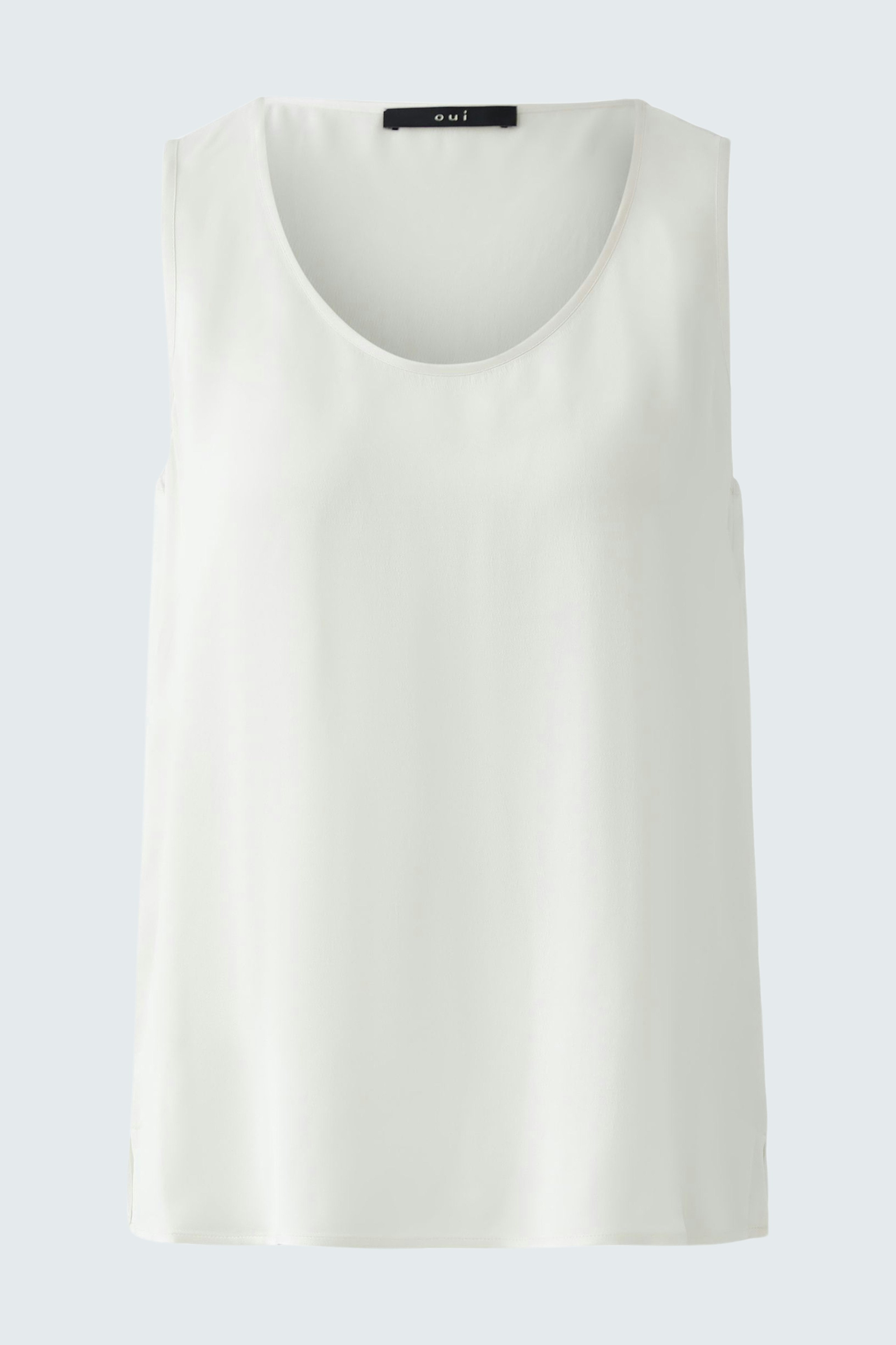 Casual women's top: A woman in a simple white sleeveless top, perfect for warm days.