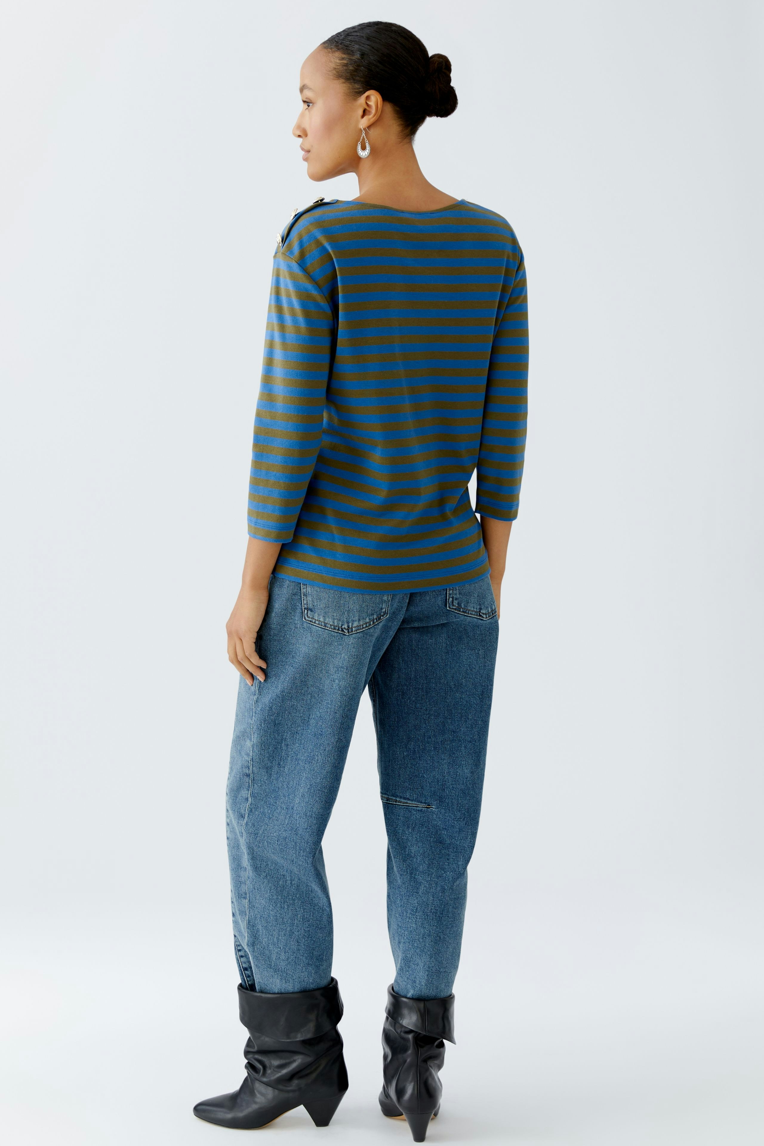 Damen Langarmshirt: Frau trägt gestreiftes Shirt in Blau und Braun, kombiniert mit lässigen Jeans.