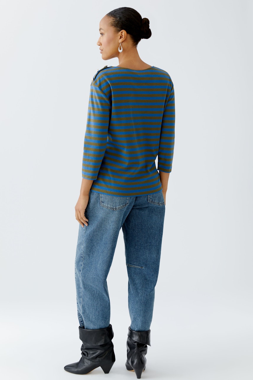 Casual women's long-sleeve shirt: A woman in a striped pullover with a relaxed fit and denim jeans.