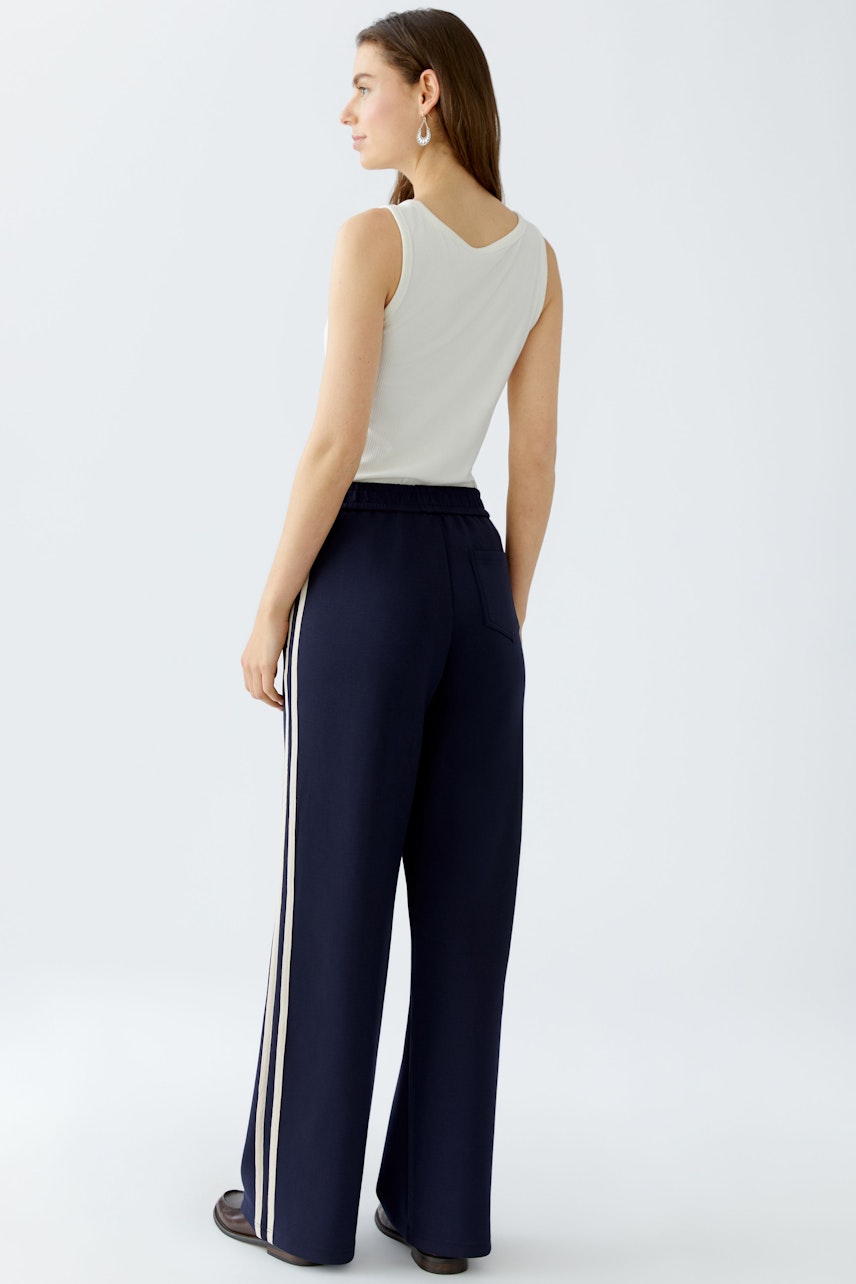 Casual women's joggers: A woman in navy joggers with side stripes, showcasing a relaxed fit.