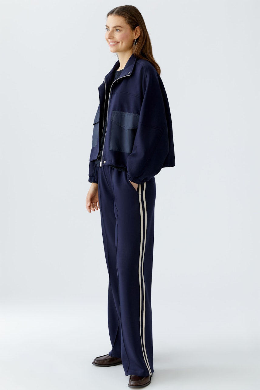 Comfortable jogger pants: Woman in navy joggers with side stripes and a relaxed fit.